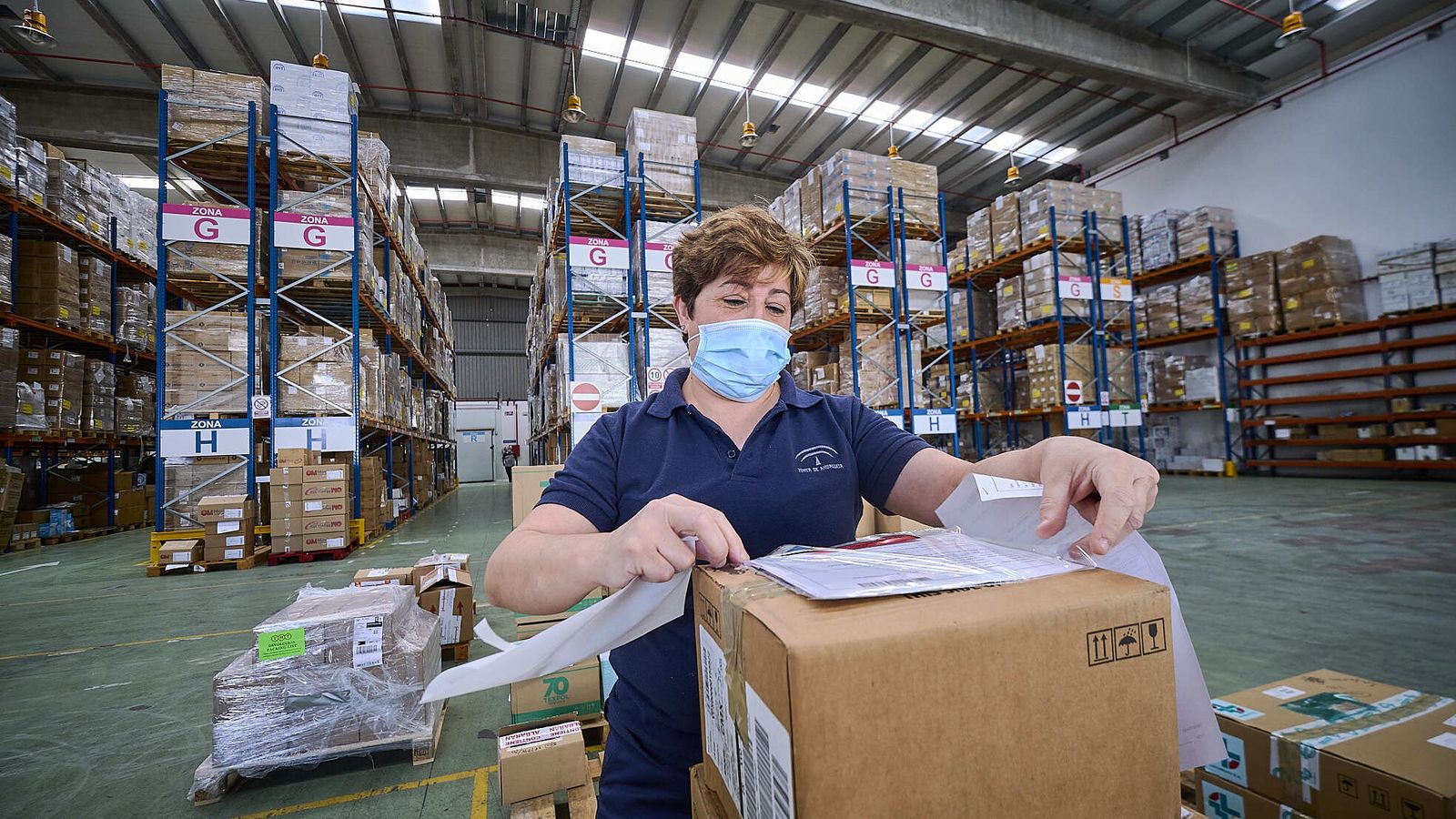 Una empleada de la Central de Compras ordenando pedidos delante de uno de los almacenes.