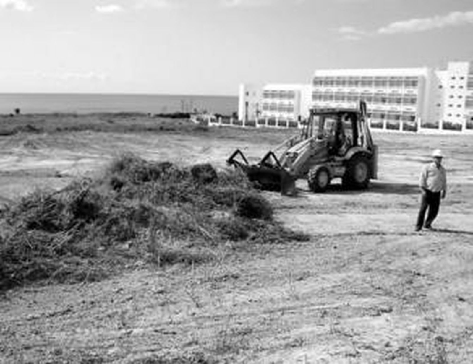 Una máquina desbroza la parcela de la carretera de la Fuente del Gallo donde se construirá el apartahotel.