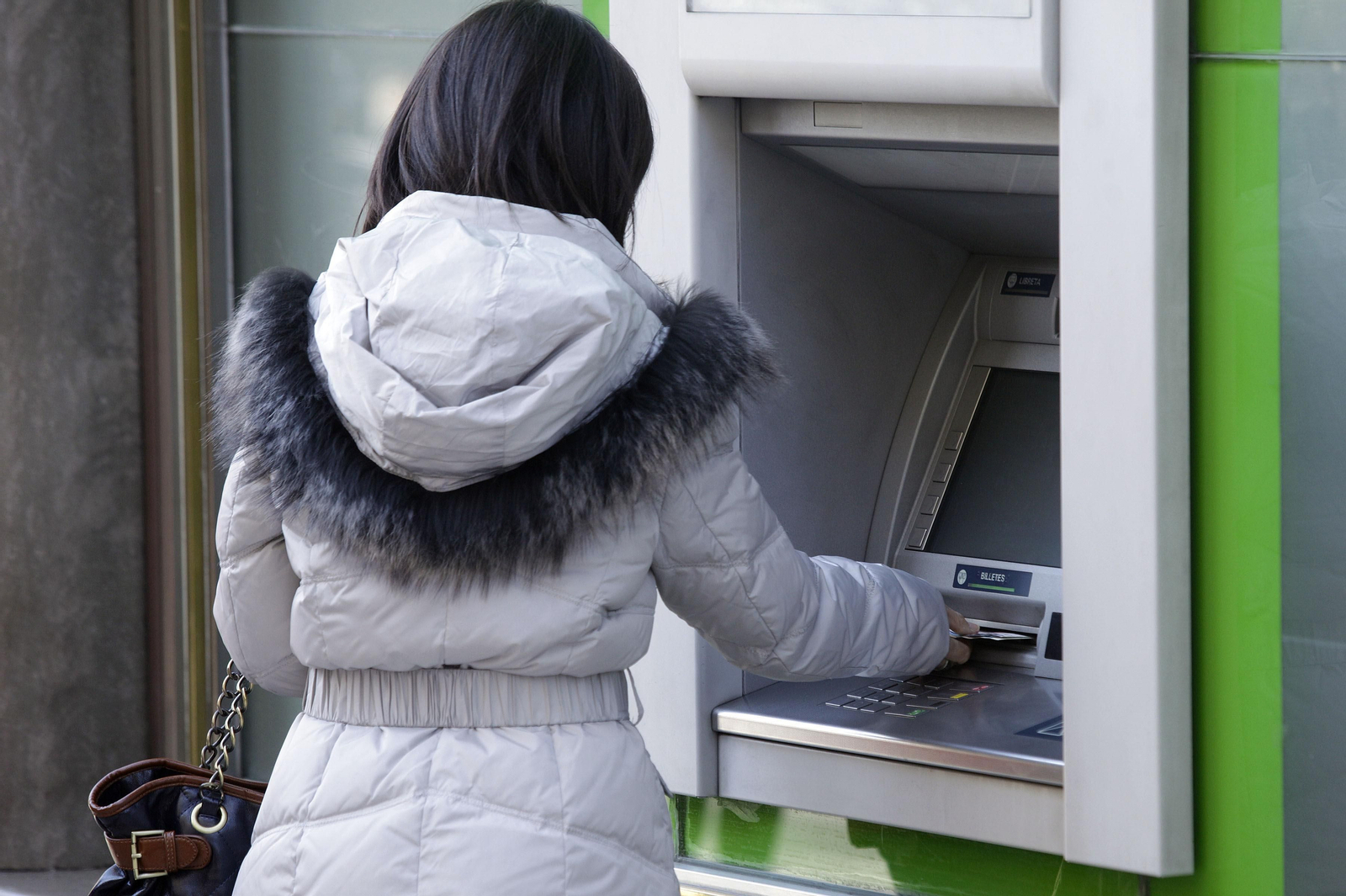 Mujer sacando dinero de un cajero.