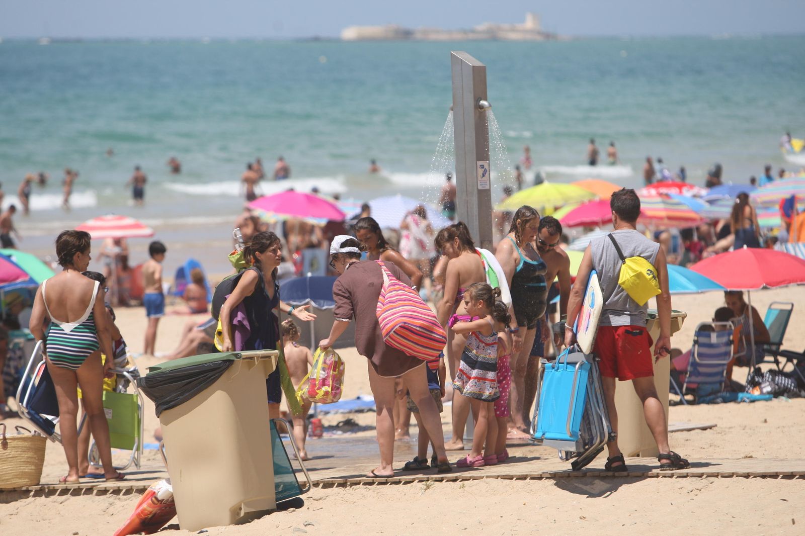 1. La playa de La Barrosa repleta de sombrillas y bañistas 2. Servicios de ducha en la segunda pista. 3. La playa chiclanera dispone de multitud de zonas recreativas para niños.