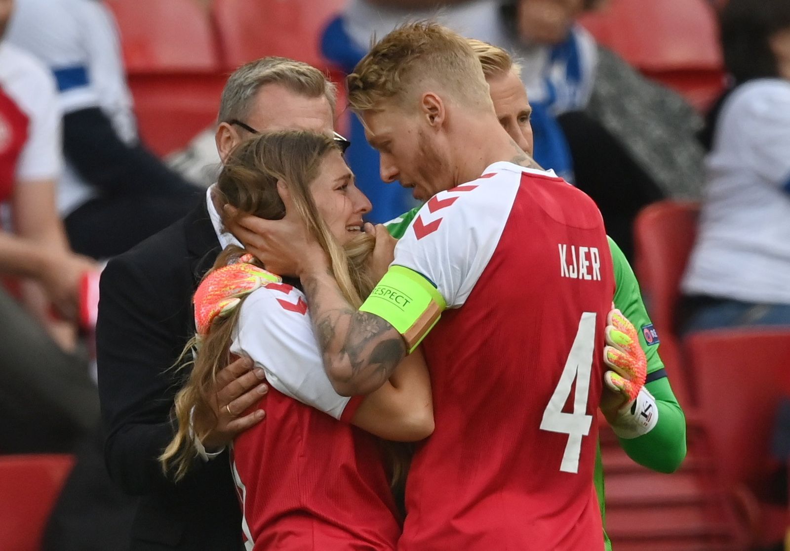 El ex sevillista Kjaer consuela a la novia de Eriksen, Sabrina Kvist Jensen, tras el suceso.