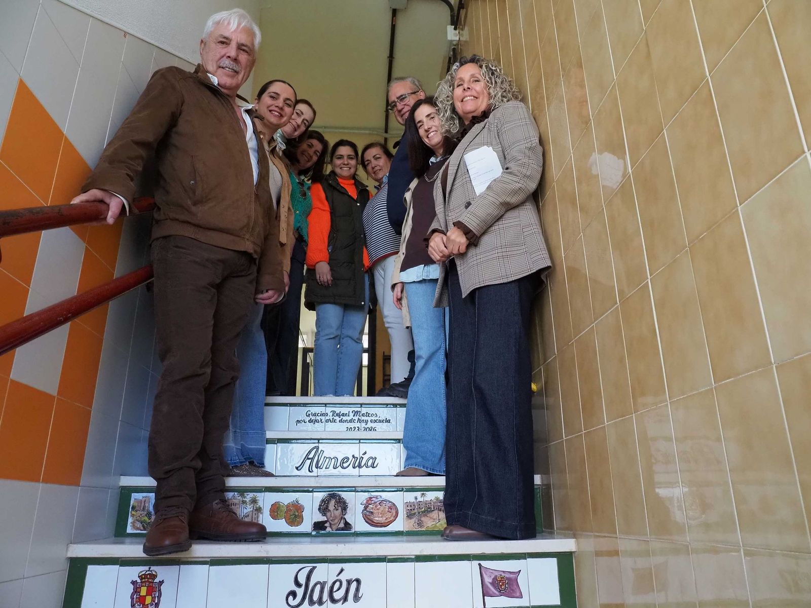 Rafael Mateos (i) y Tay Macías (d) junto a parte de la escalera con otros miembros de la comunidad educativa del centro cartayero