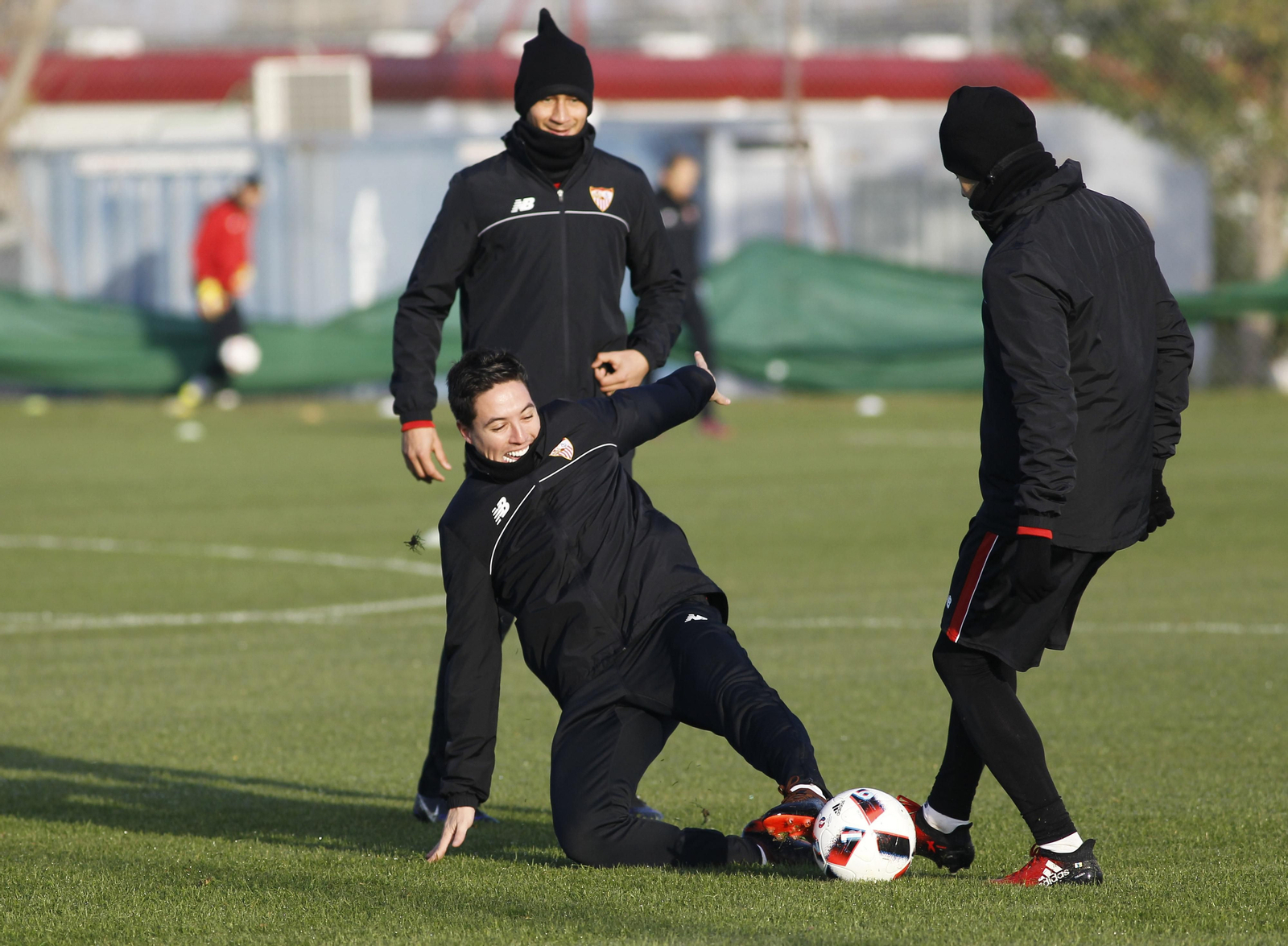 Nasri se tira al suelo mientras sonríe para arrebatar un balón a Vitolo en presencia de Ganso.