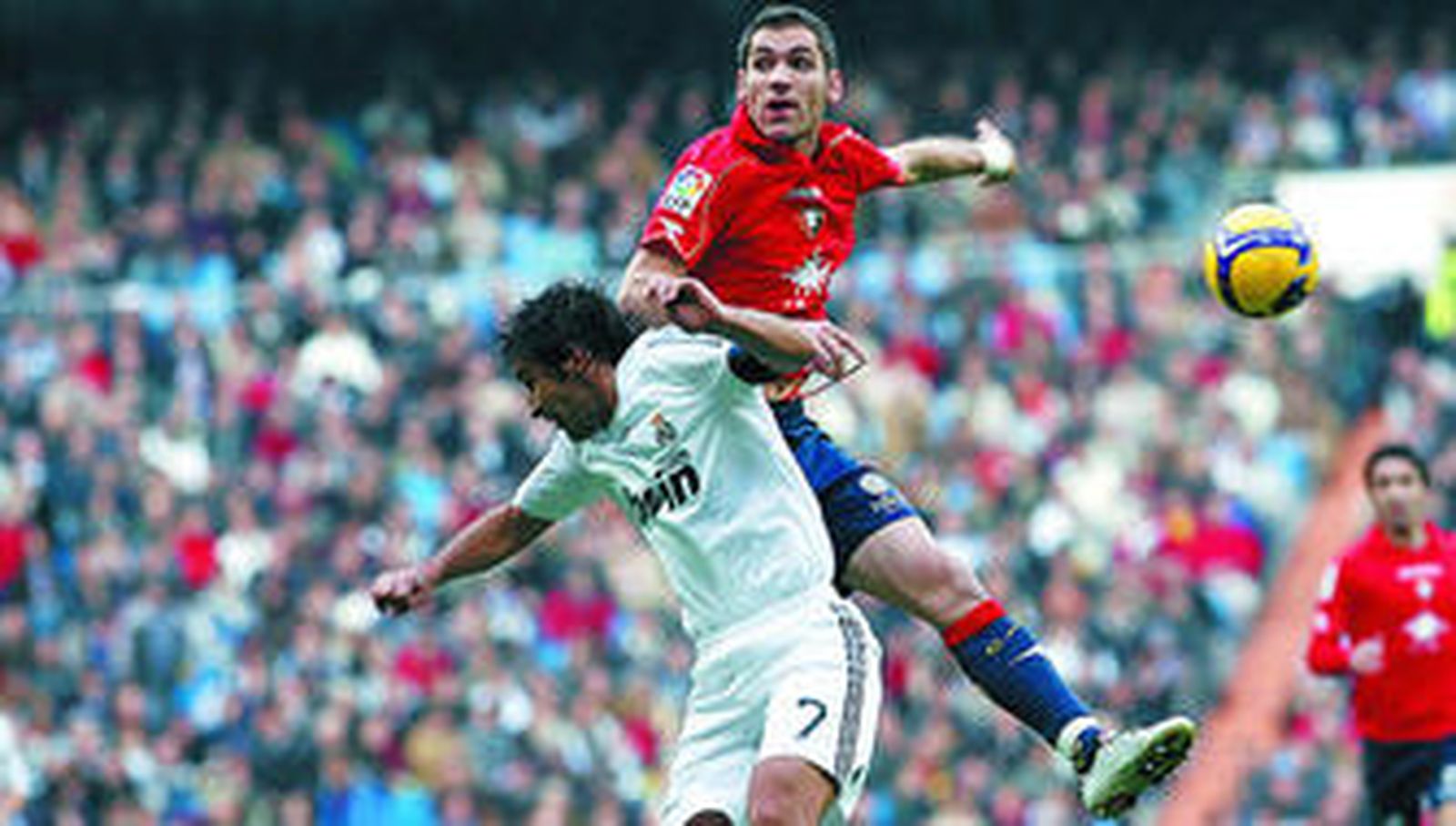 Raúl salta con el defensor navarro Josetxo durante una jugada del encuentro disputado ayer en el Bernabéu.