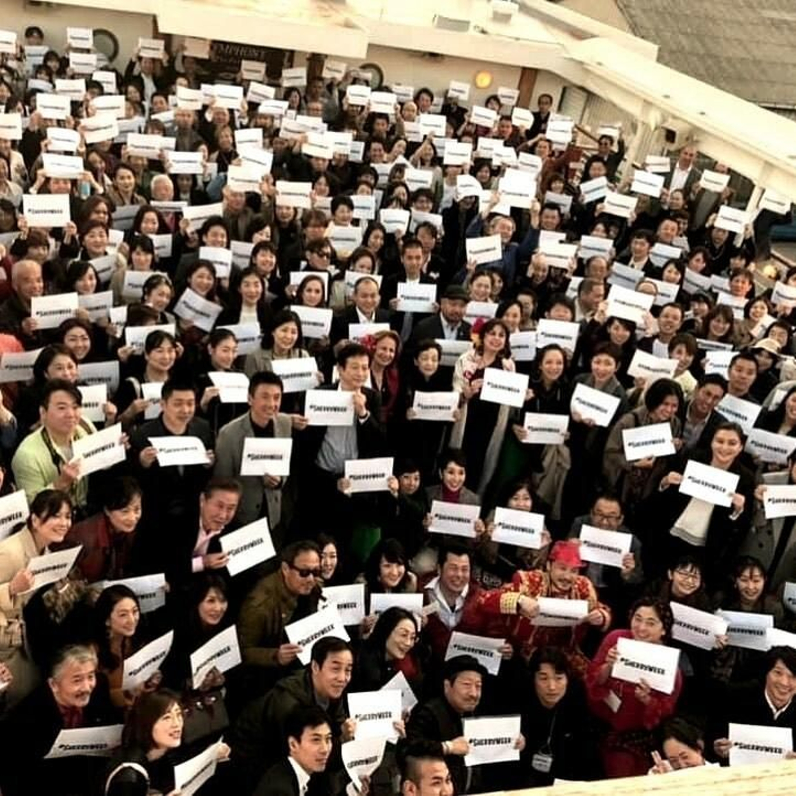 Decenas de japoneses muestran el cartel de la Sherry Week a bordo del crucero del jerez en Tokio.