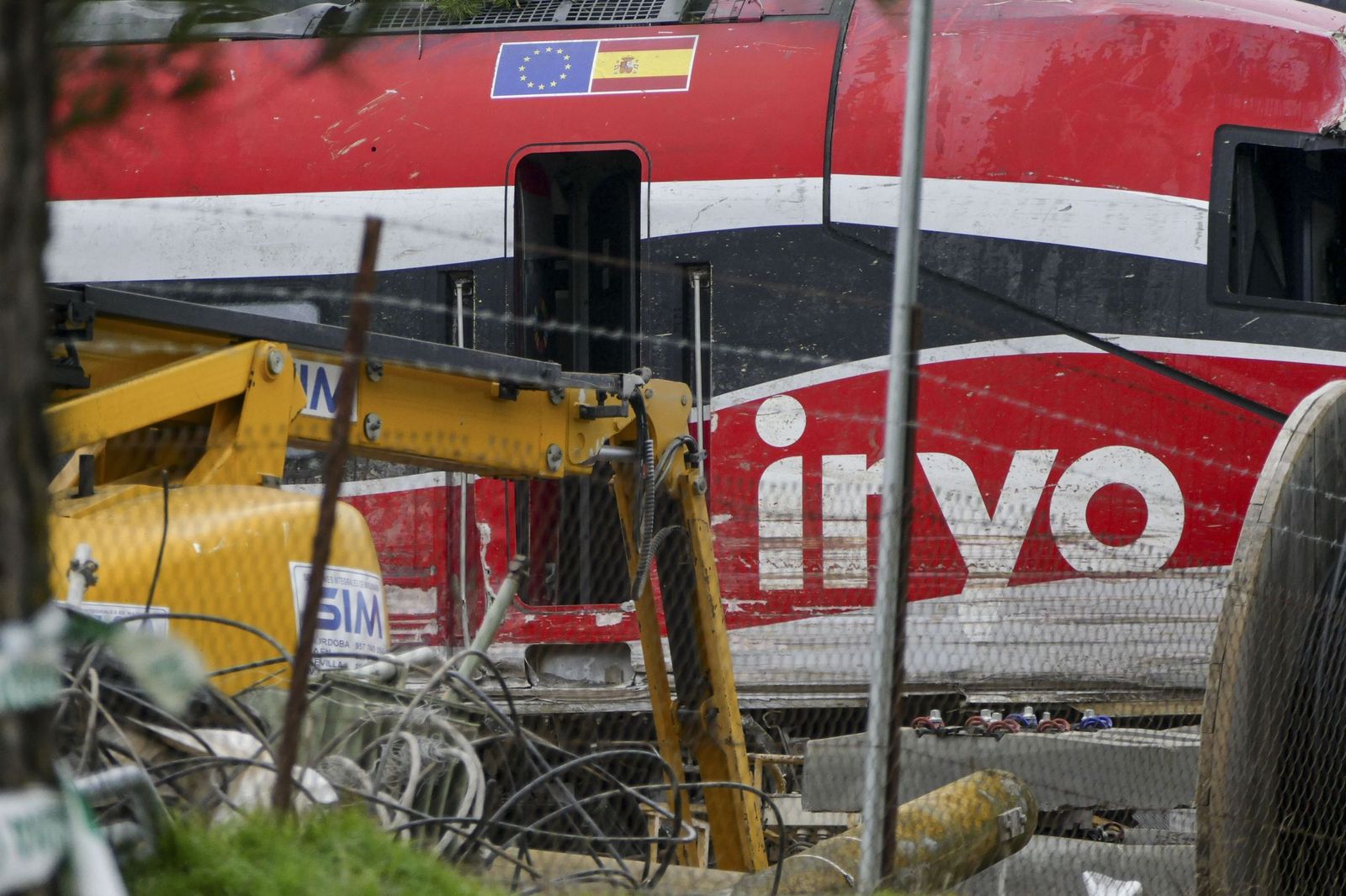 Una grúa trabaja sobre uno de los trenes accidentados en Adamuz