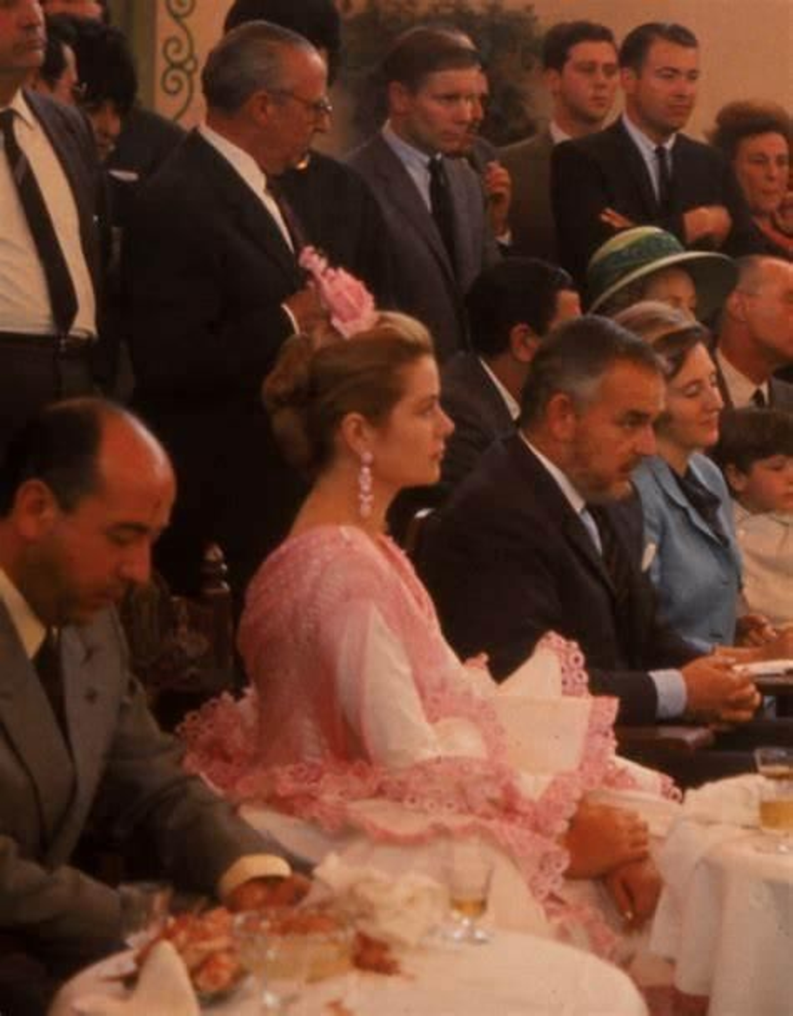 Grace Kelly, con vestido de volantes blancos y mantoncillo y flor rosas, junto a Rainiero de Mónaco, en la recepción que le brindó el ayuntamiento sevillano en la Feria de Abril.