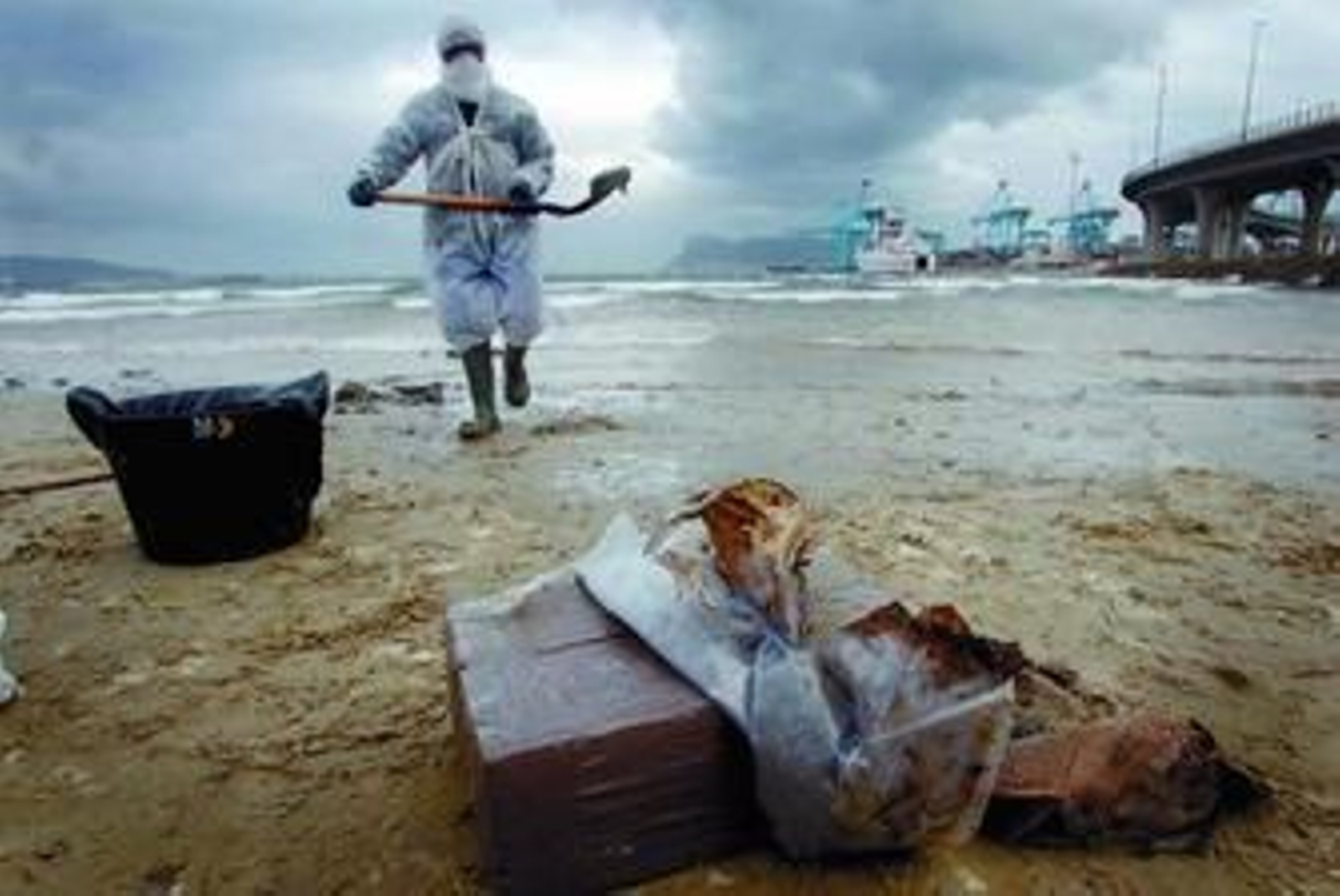 Un operario limpia la costa algecireña del hidrocarburo desprendido por el 'New Flame', ayer.