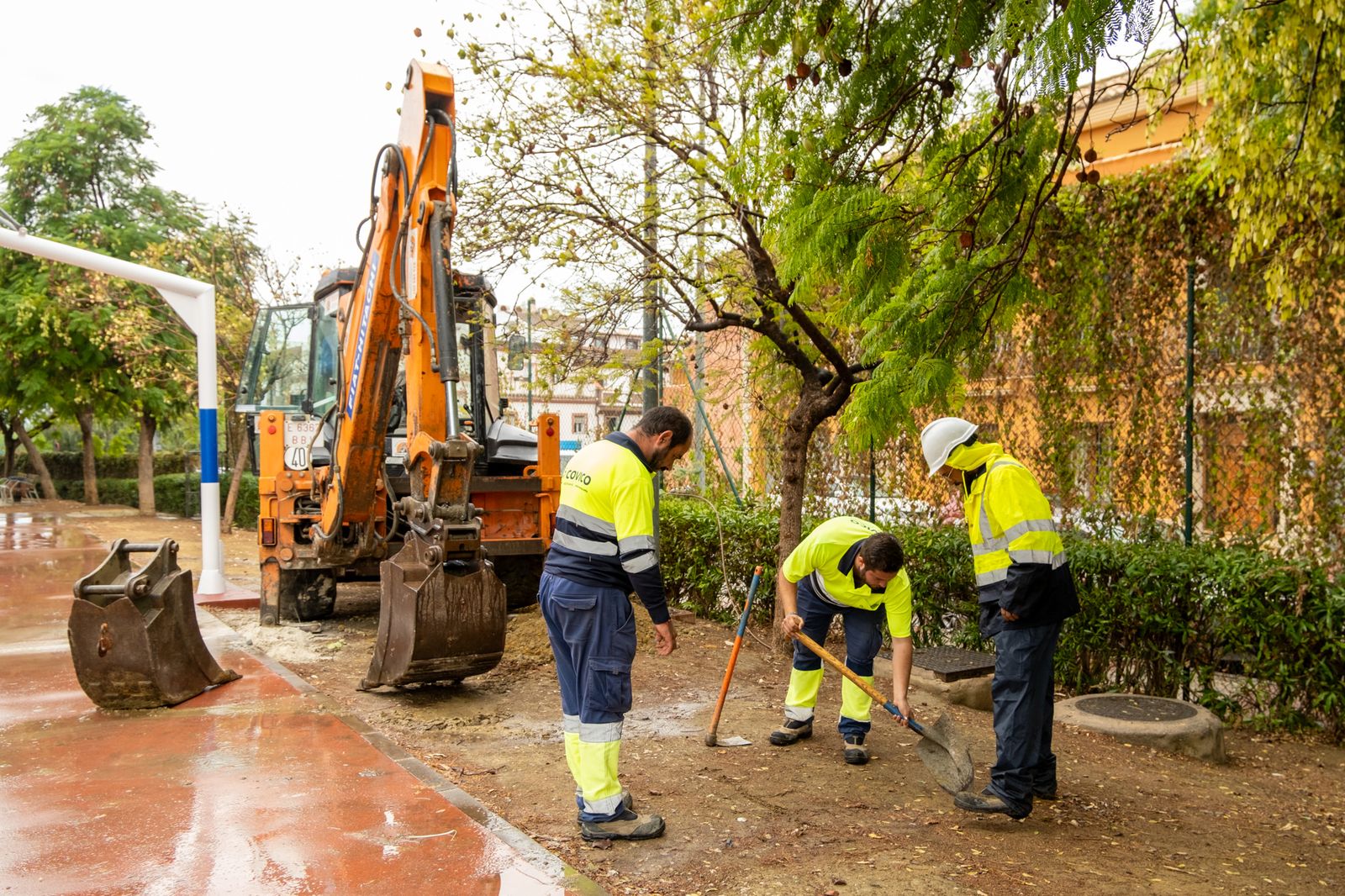 Operarios realizando trabajos de mejora en la pista deportiva.