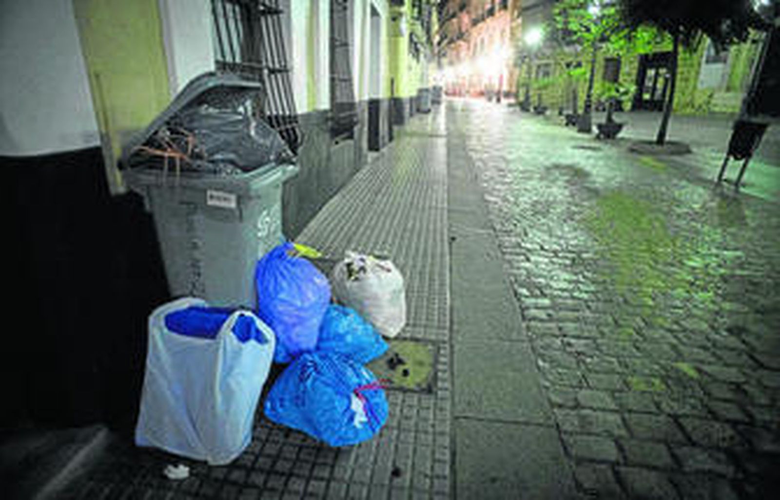 La imagen de varias bolsas de basura alrededor de un contenedor lleno se suele repetir en el centro de la ciudad.