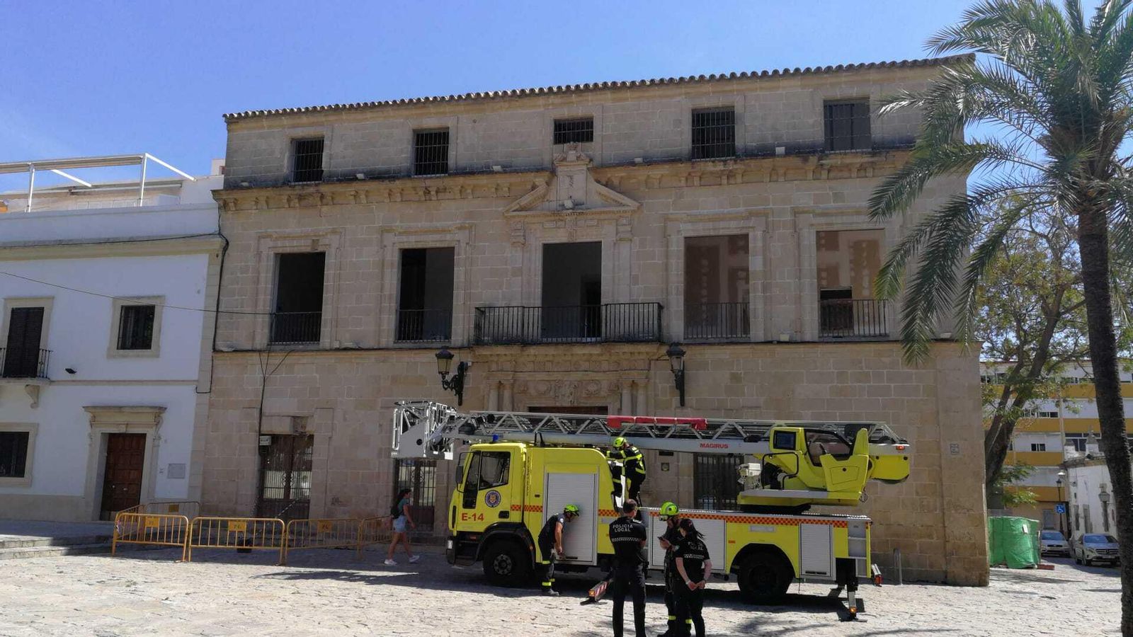 Los Bomberos y la Policía Local, durante la intervención para acordonar parte de la fachada principal.
