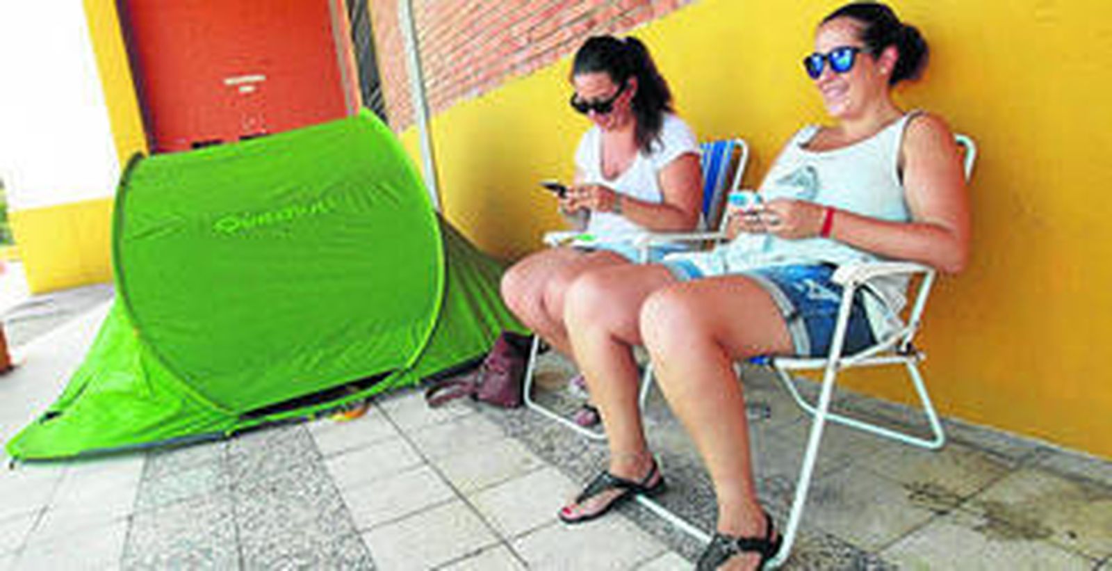 Imagen de las seguidoras esperando en la puerta de entrada de la plaza de toros junto a la tienda de campaña.