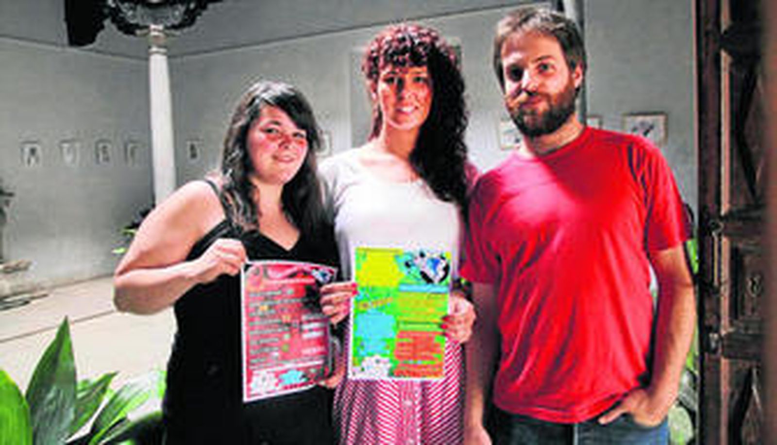 Los integrantes de Cenet Consulting posan con los carteles promocionales en el interior de la Casa de Porras, una de las sedes del festival.