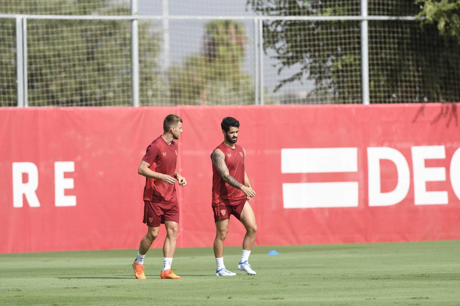 Isco conversa con Rakitic en el entrenamiento sevillista.