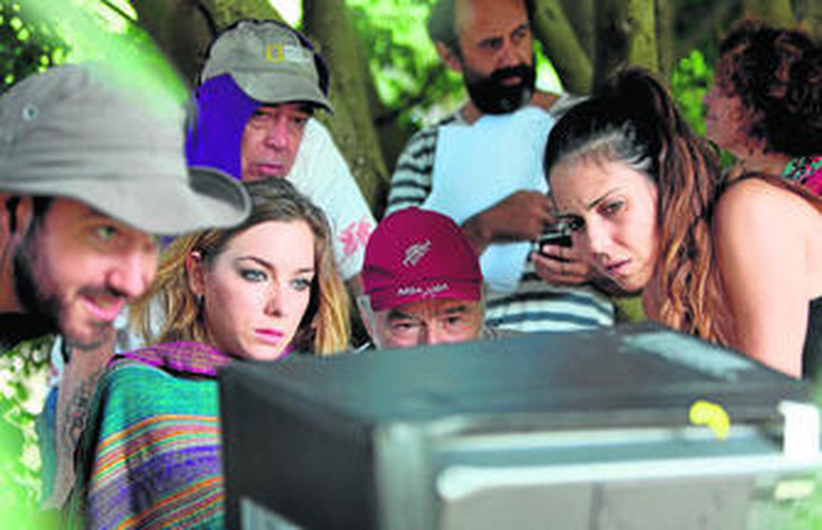 Parte del equipo técnico, con el director y la actriz en el centro, chequean el resultado de la incipiente grabación.