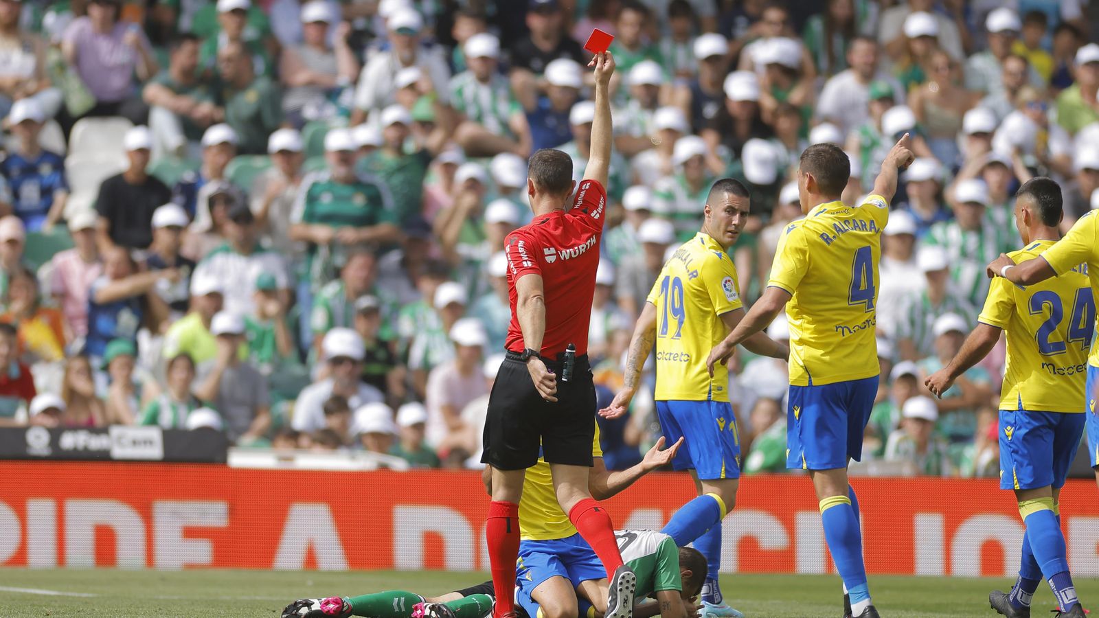 Cuadra Fernández le muestra la cartulina roja a Canales, en el césped con el rostro tapado..