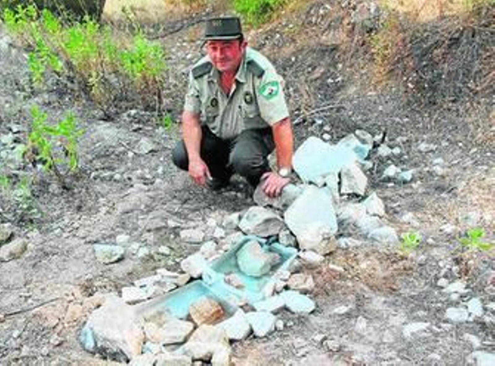 Un guarda forestal, junto a uno de los bebedores habilitado en la sierra.