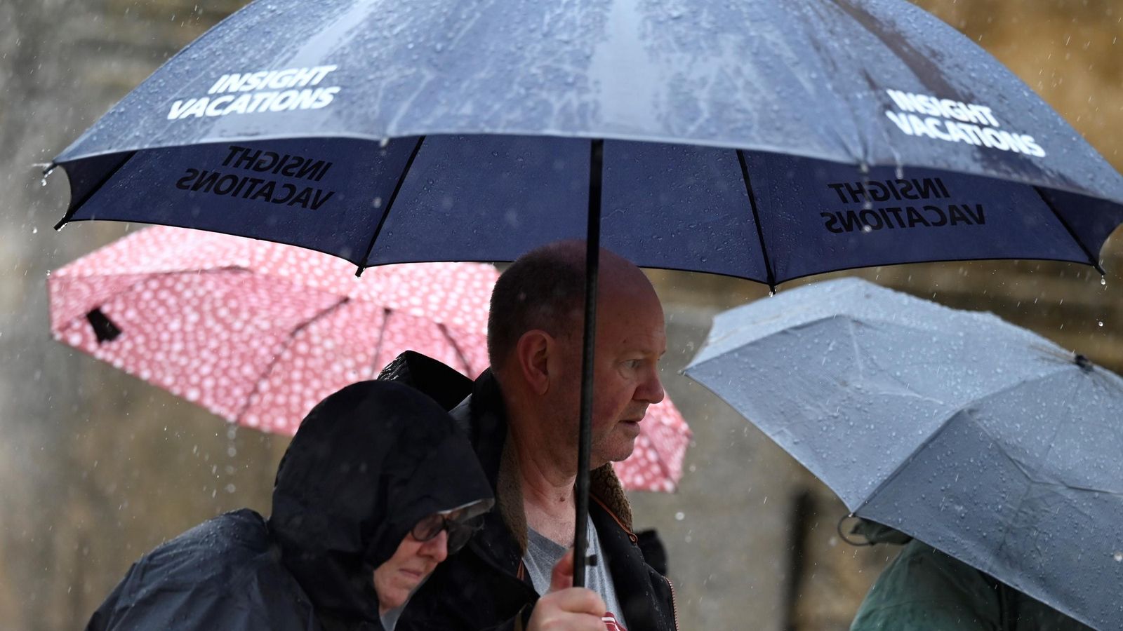Turistas se protegen de la lluvia este domingo en Córdoba