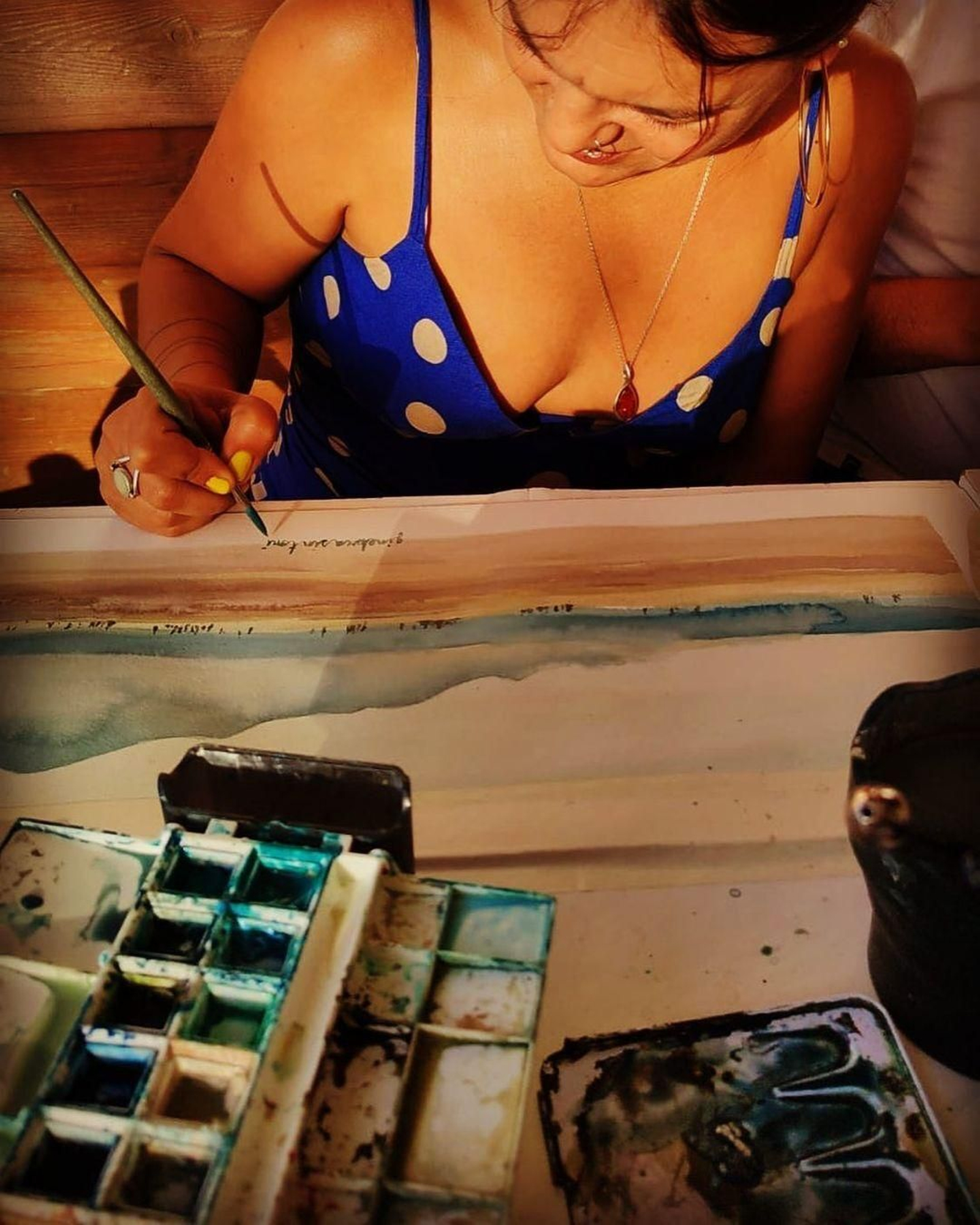 Neila Pascual con sus acuarelas en el chiringuito tarifeño de 'Carbones 13'