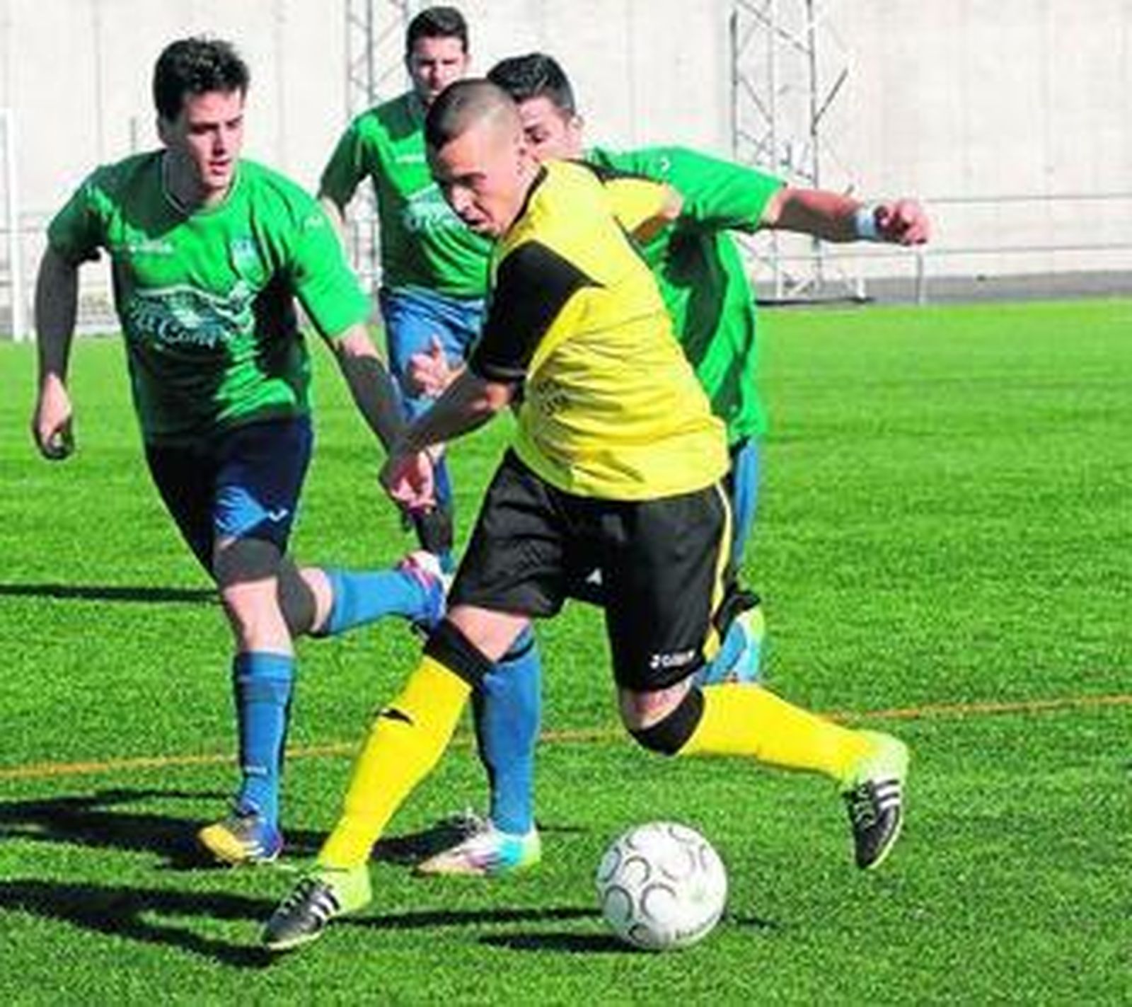 Un jugador de Las Palmeras controla el balón ante la presión de dos jugadores del Almodóvar.