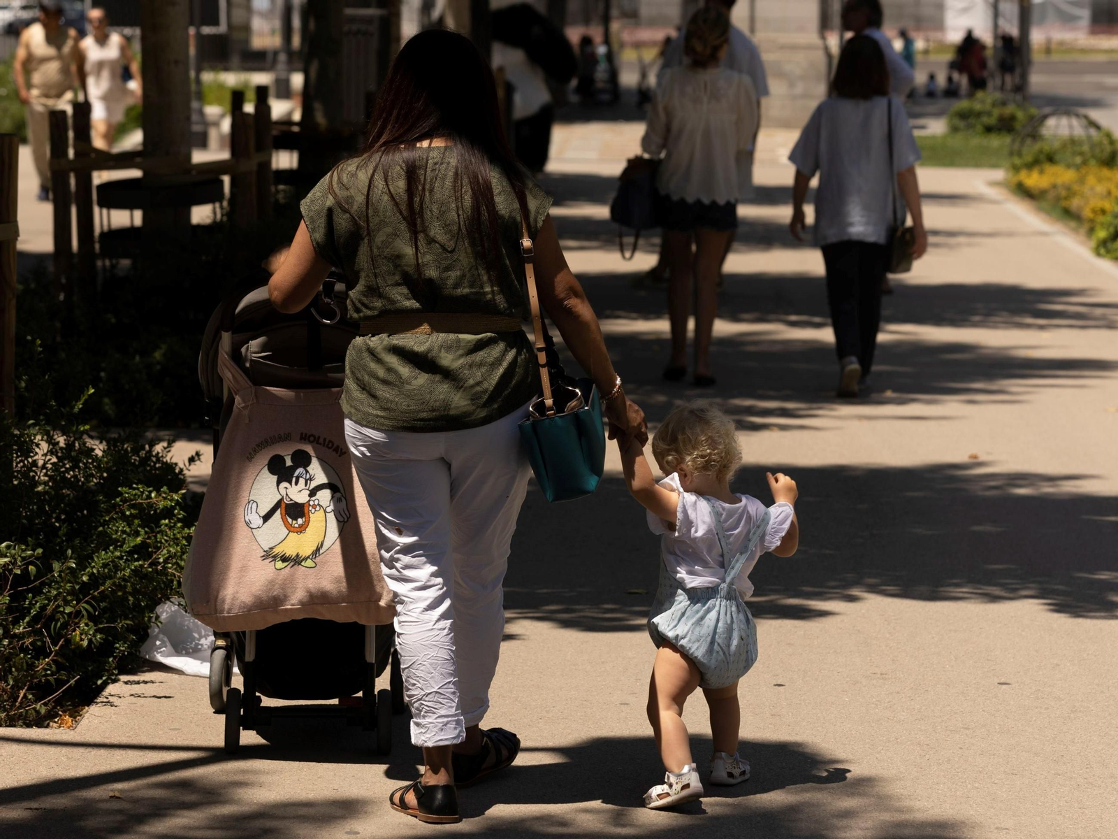 Una madre paseando con su hijo.