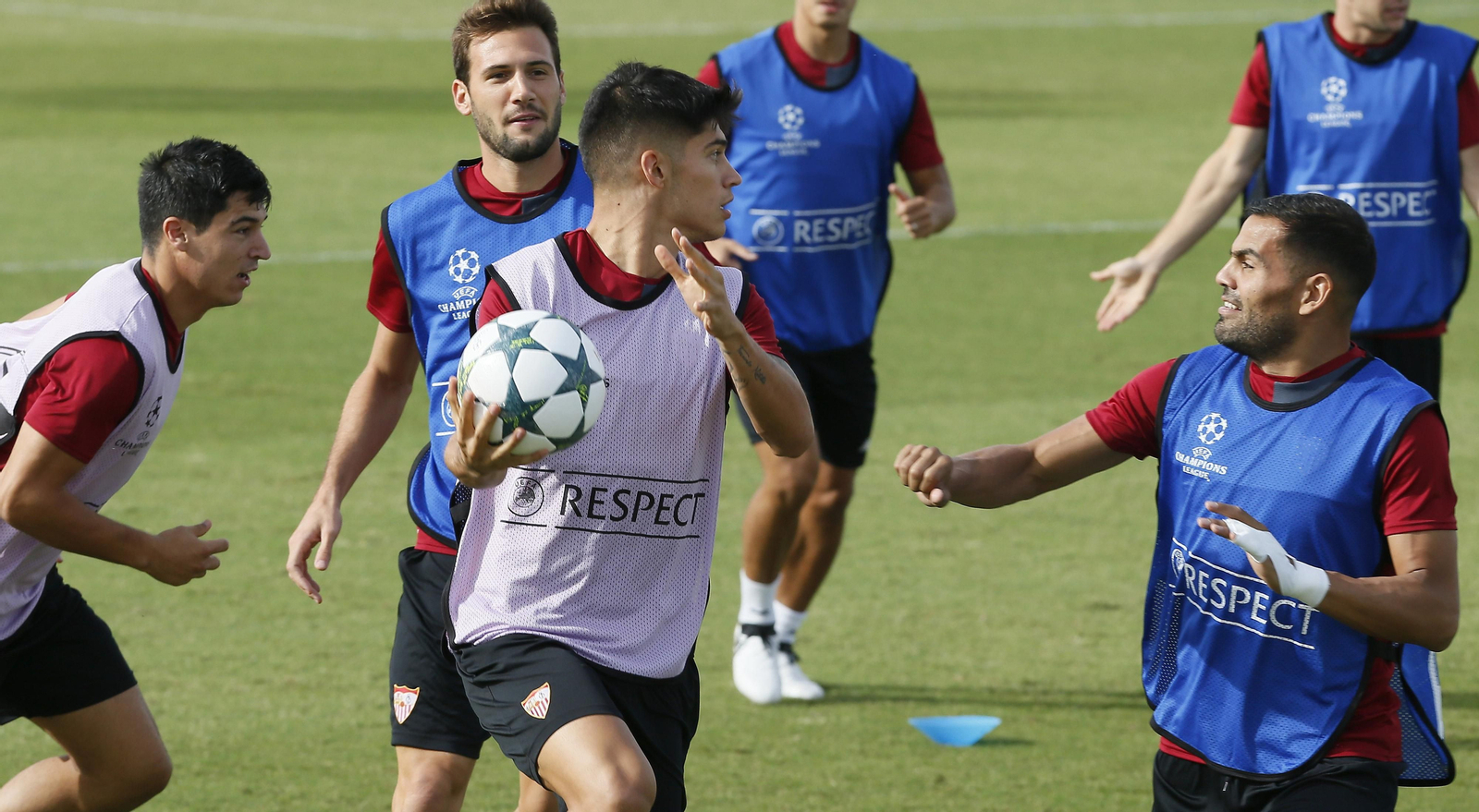 Joaquín Correa corre con un balón en la mano seguido de Franco Vázquez en el calentamiento de una sesión.