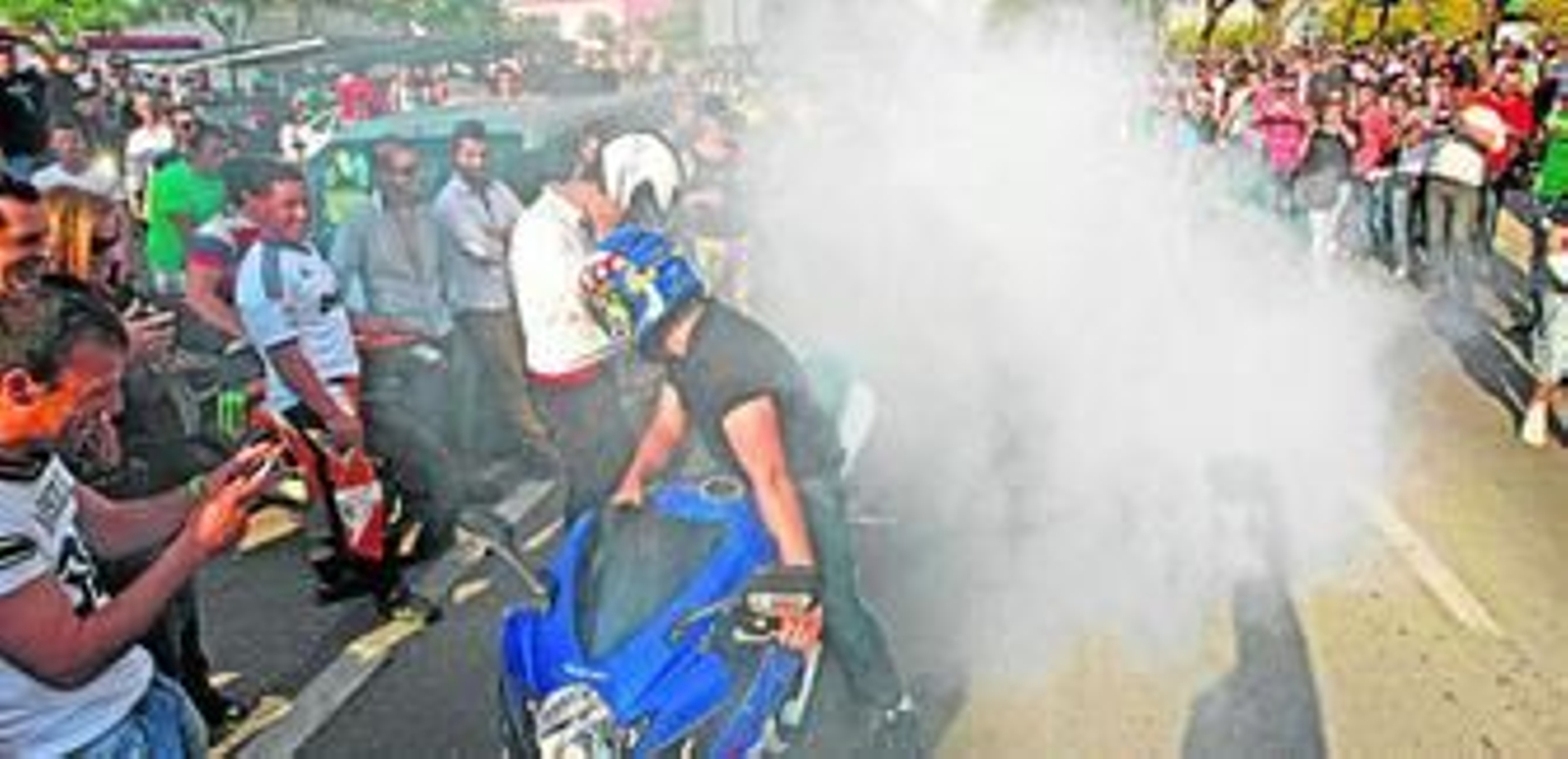 Un aficionado quema rueda en la avenida de Europa. El público inmortaliza el momento con cámaras y teléfonos móviles.