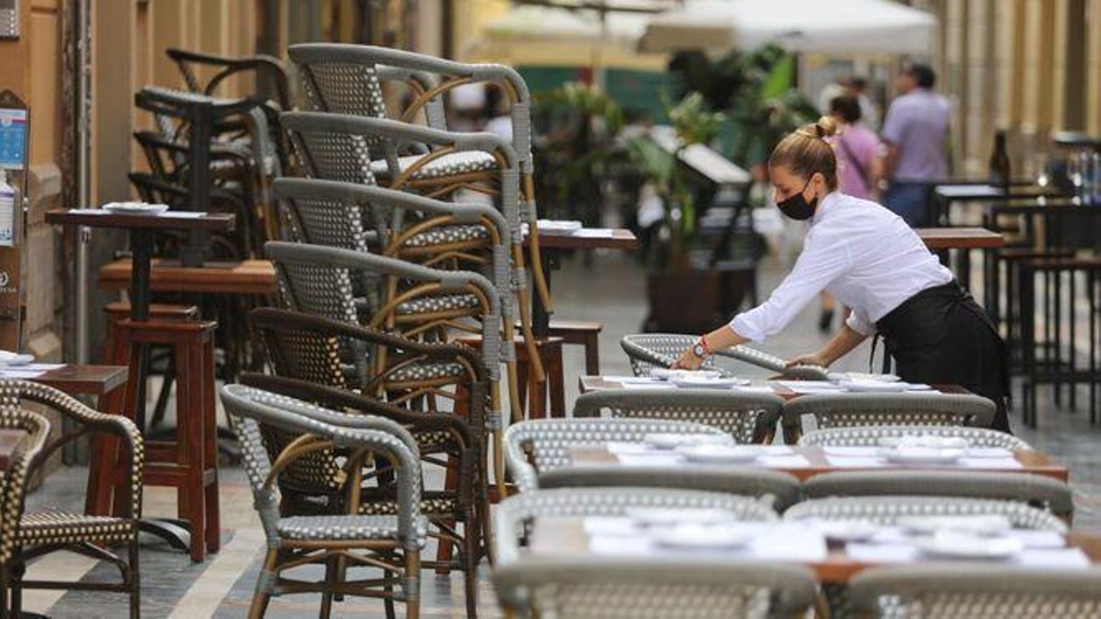 Camarera montando una terraza en el centro de Málaga.