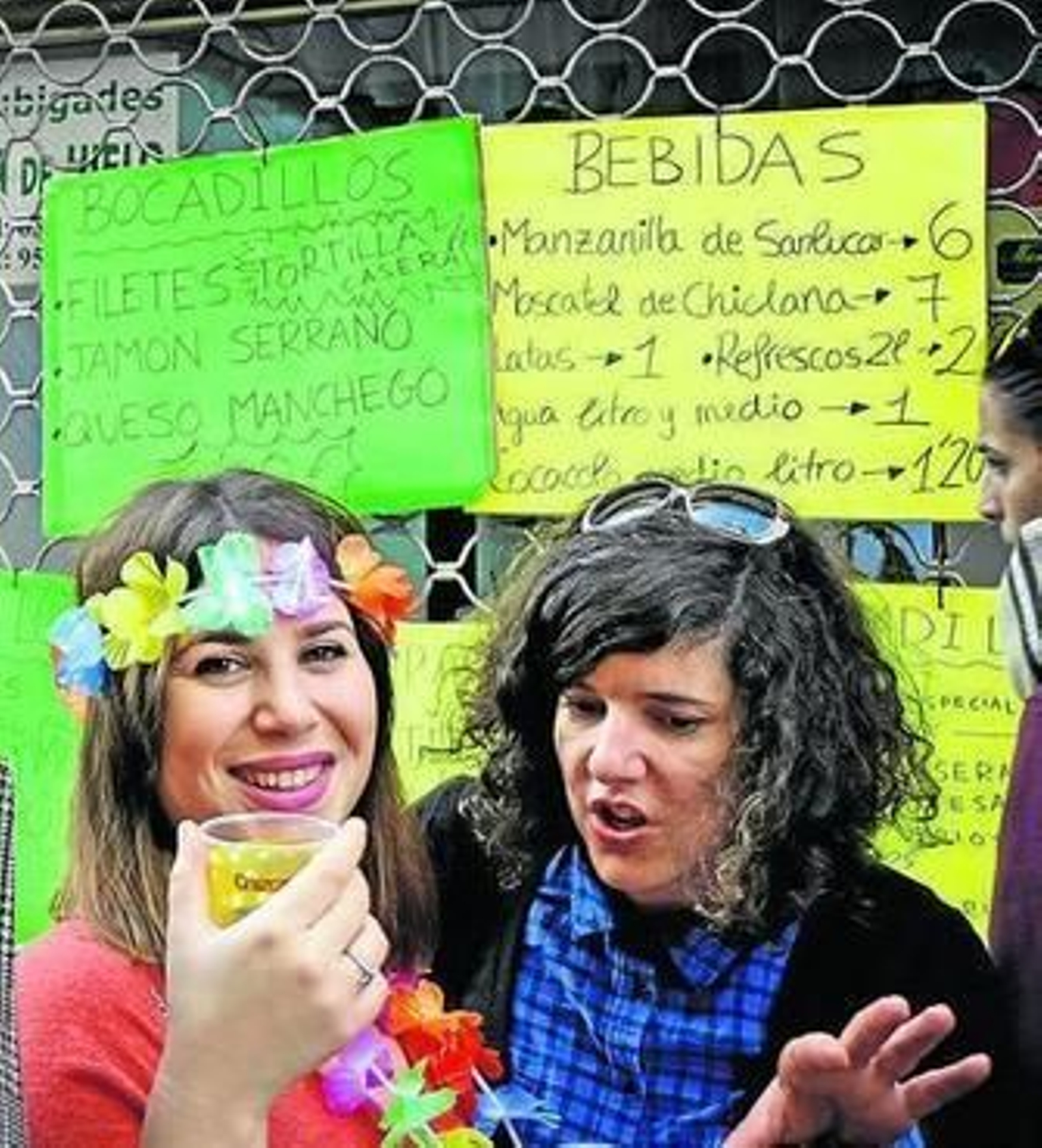 Dos jóvenes delante de los carteles de un establecimiento el domingo.