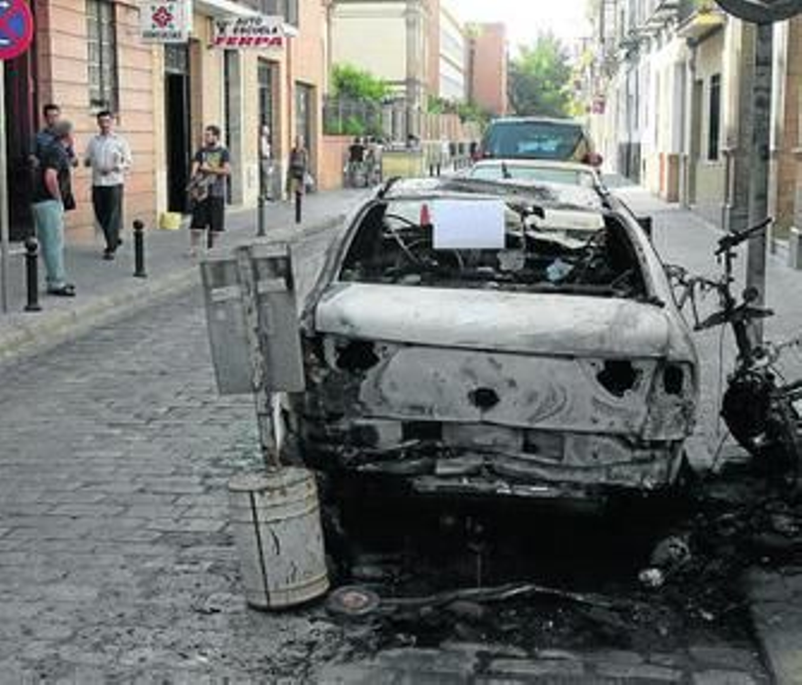 Uno de los coches calcinados, ayer por la mañana en la calle Conde de Bustillo.