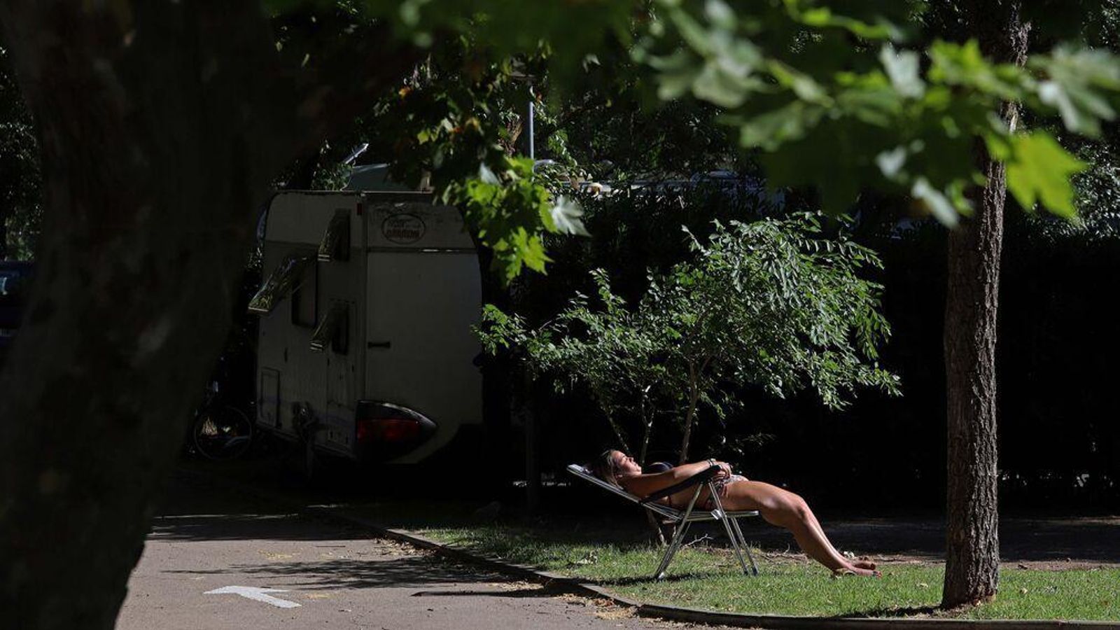 Una mujer toma el sol en las instalaciones de un camping.