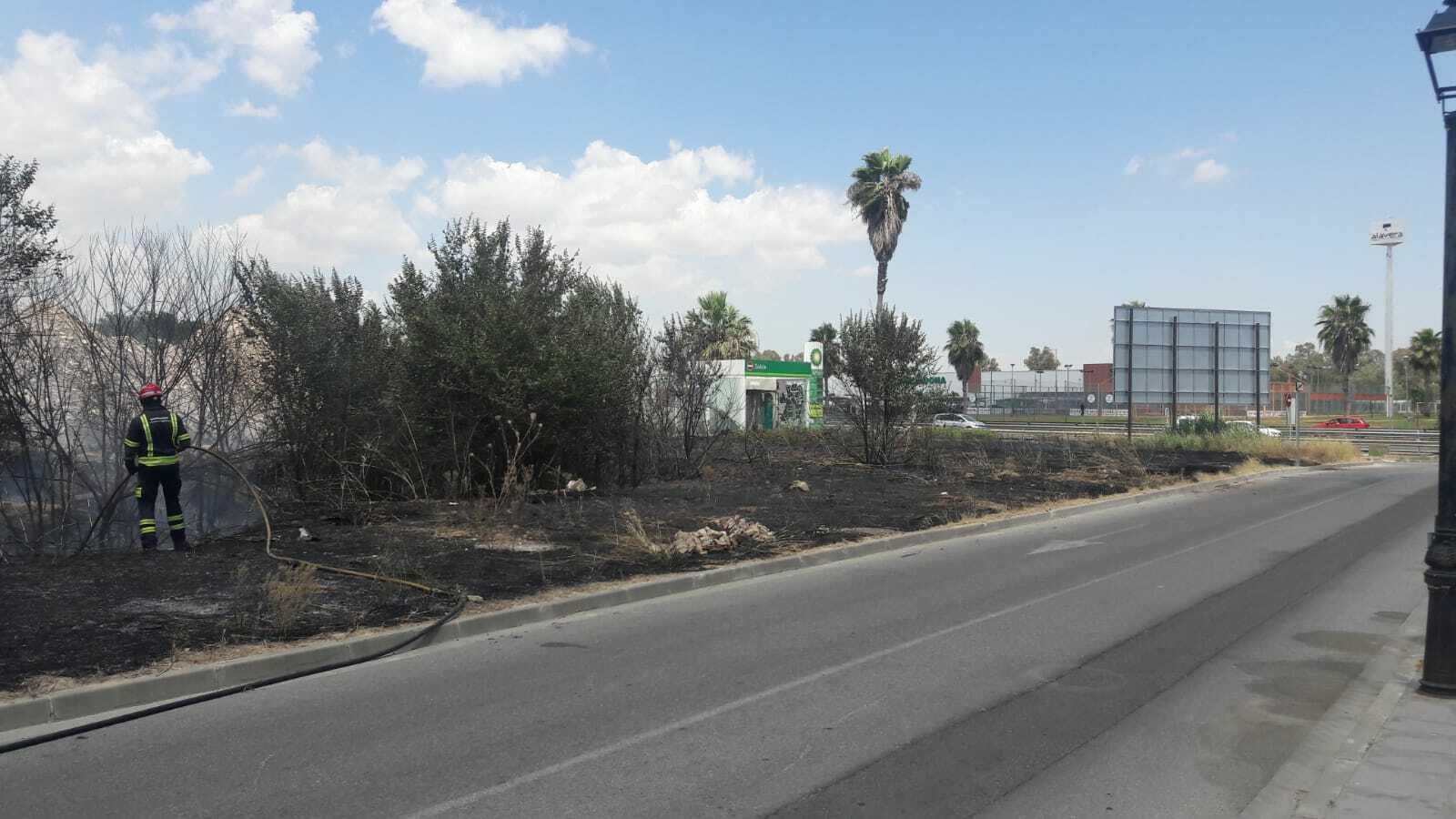 Un bombero refresca una zona próxima a la gasolinera