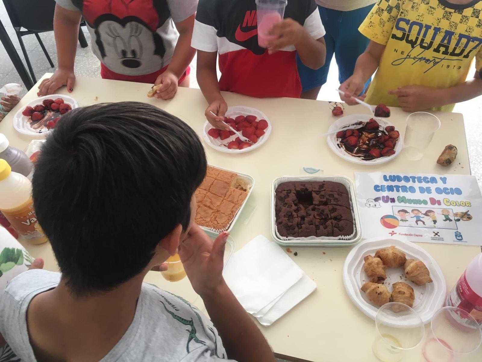 Varios niños meriendan en la ludoteca de la Coordinadora Alternativas premiada por la Fundación Cepsa.