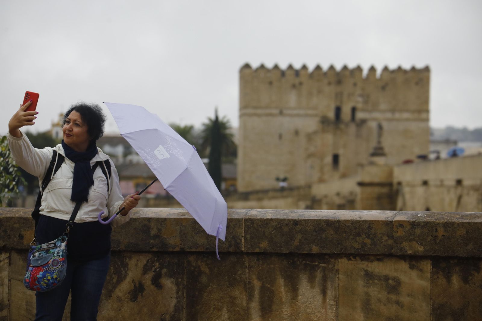 Una turista se hace un selfie en el entorno del Puente Romano.