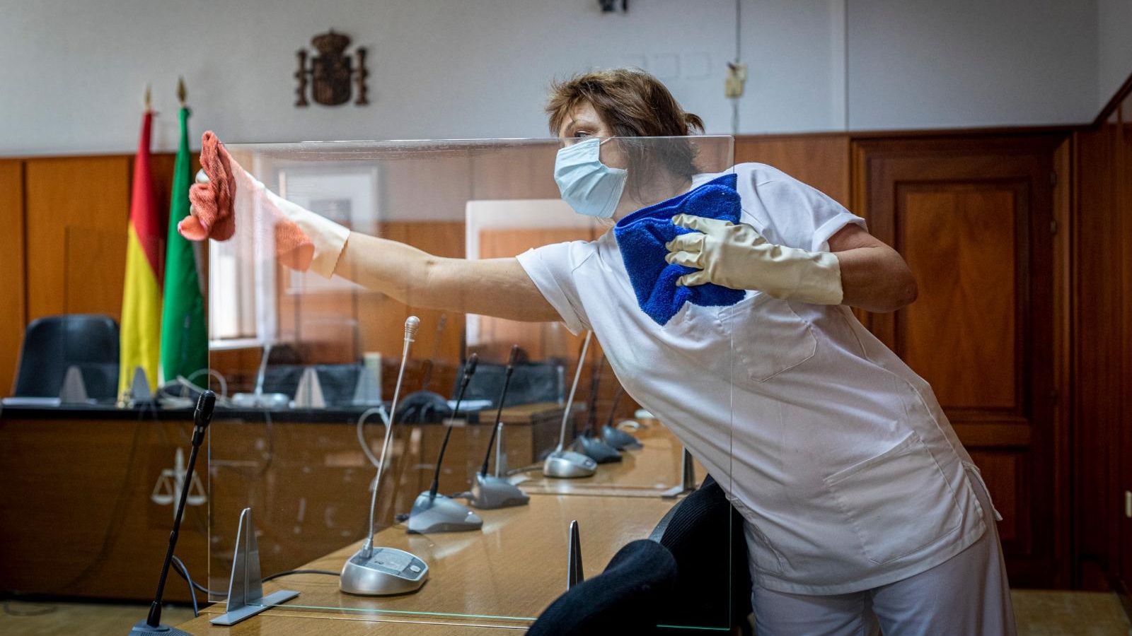 Una limpiadora repasa las mamparas recién instaladas en la Audiencia.