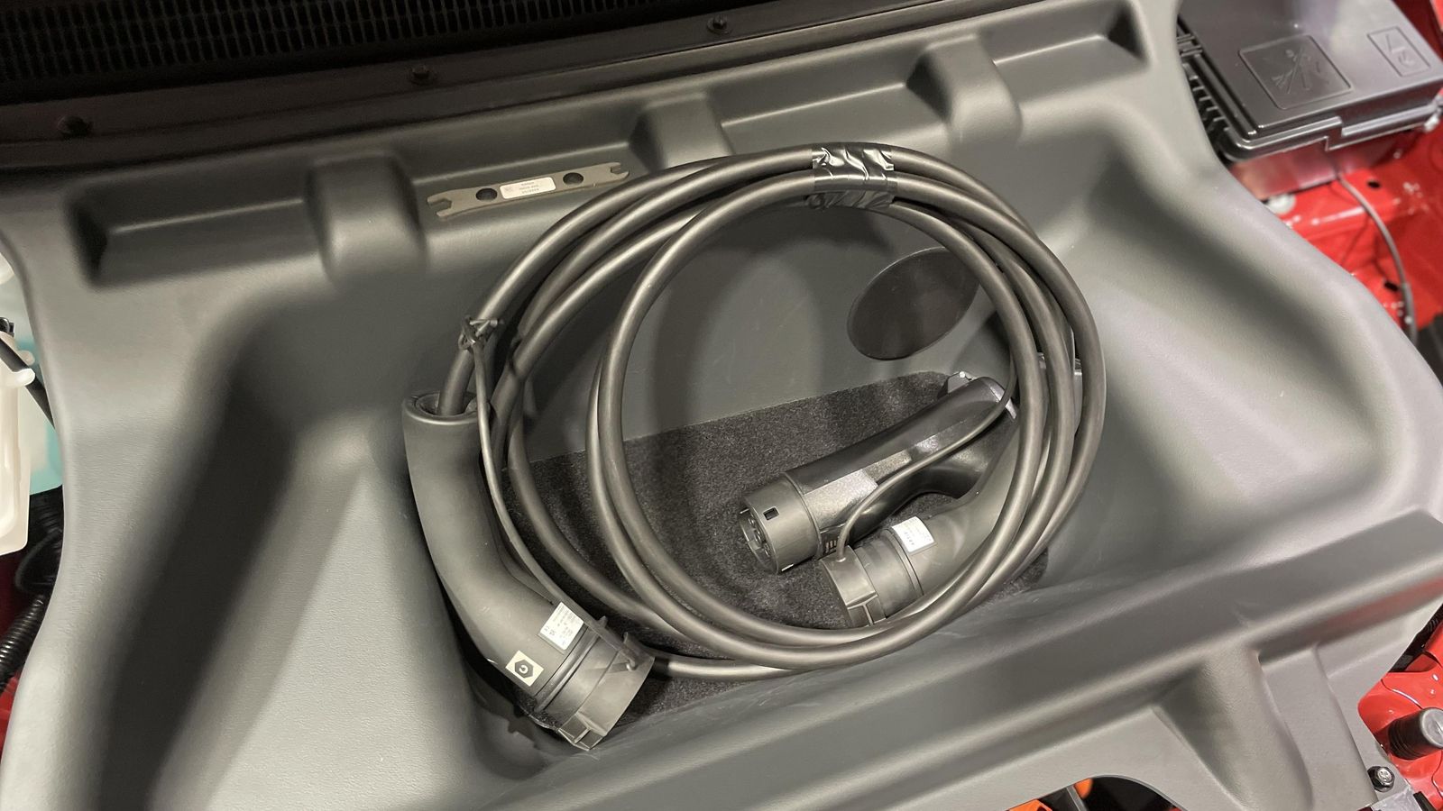 Entre los recursos curiosos de este Dacia está esta bandeja bajo el capó en el que cabe el cable y que, para acceder a lo que hay debajo, puede desmontarse con la llave que incorpora.