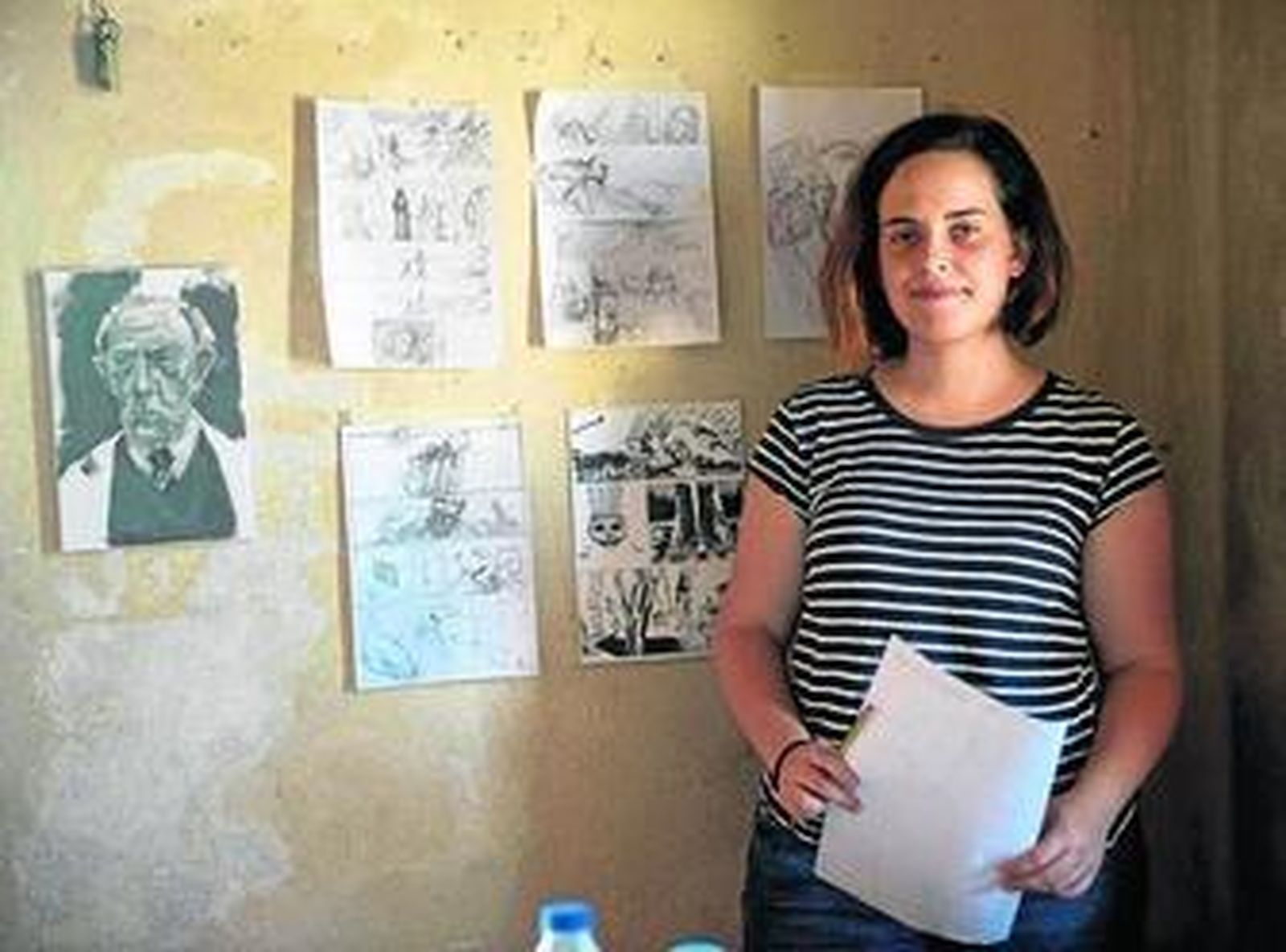 Kry García en su estudio del Castillo de Santa Catalina junto a algunas páginas de sus cómics.
