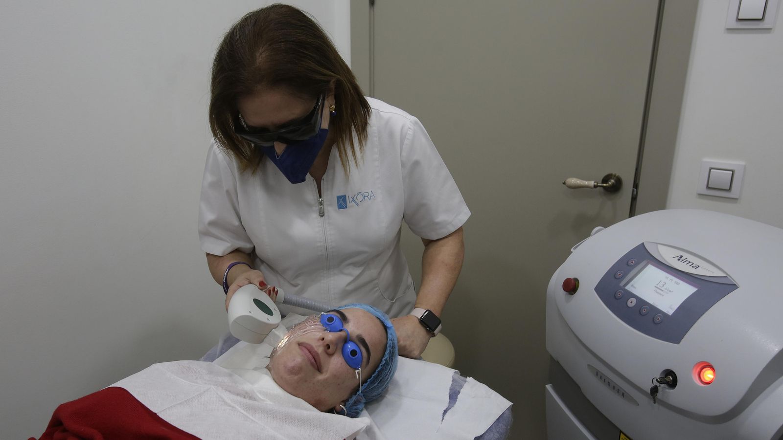La doctora junto a una paciente durante un tratamiento facial con luz pulsada intensa.