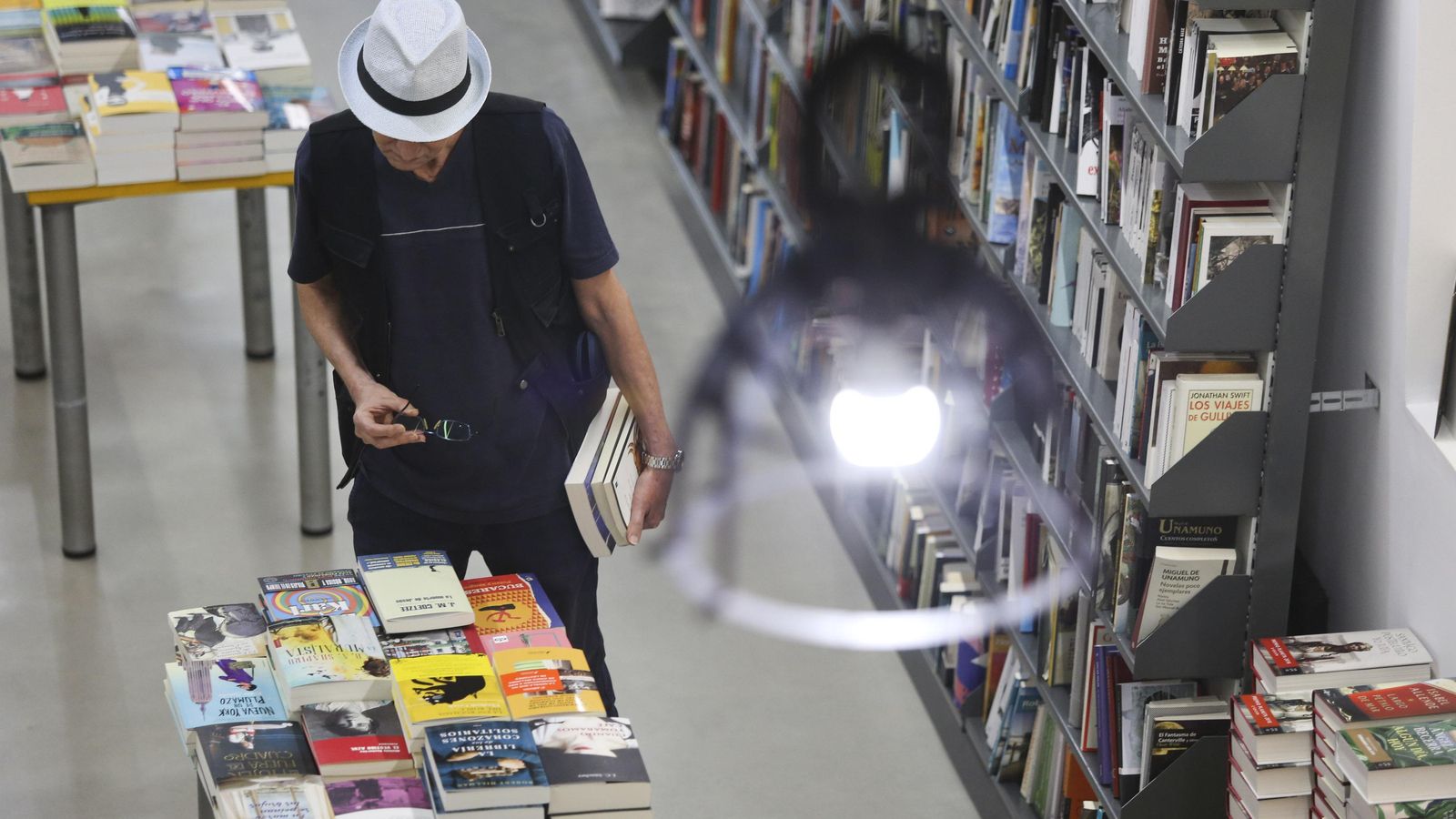 Un lector observa ejemplares de una librería.