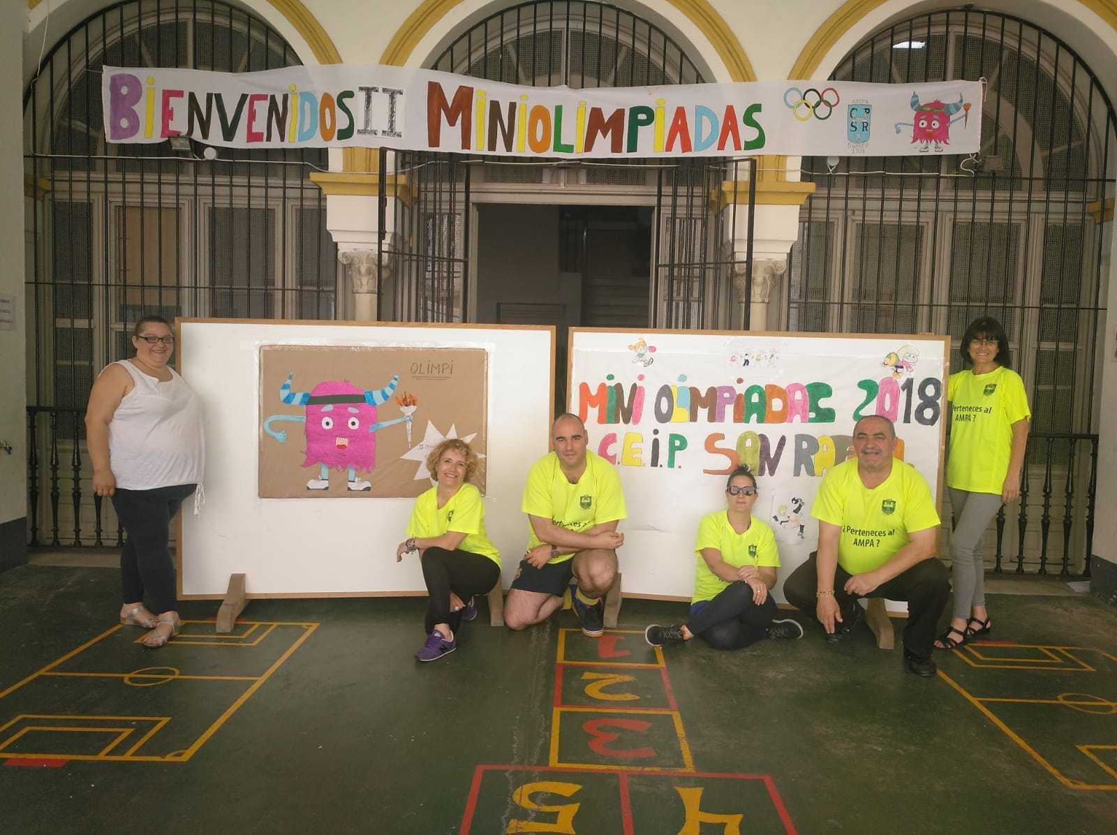 Integrantes de la AMPA de San Rafael ante carteles de las miniolimpiadas.