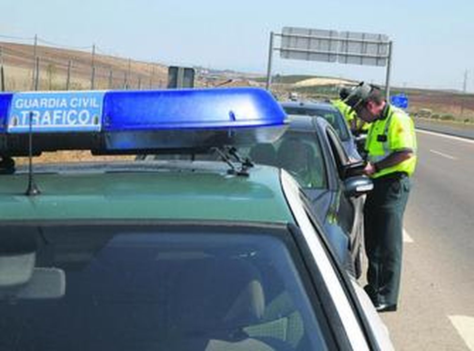 Un guardia civil extiende una multa por exceso de velocidad a un conductor detectado por un radar móvil, en una imagen de archivo.