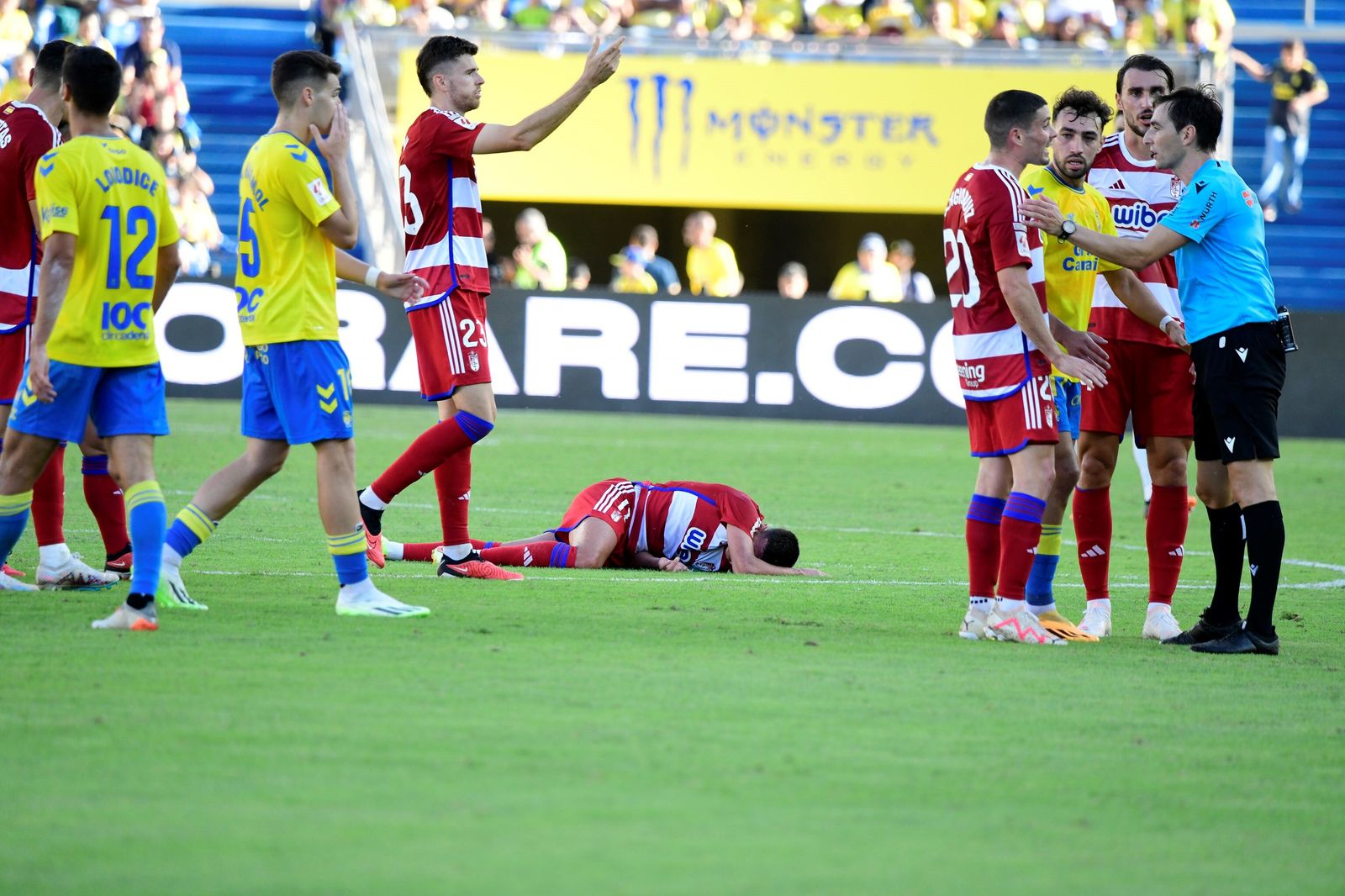 Jugadores del Granada protestan al árbitro con Uzuni en el suelo
