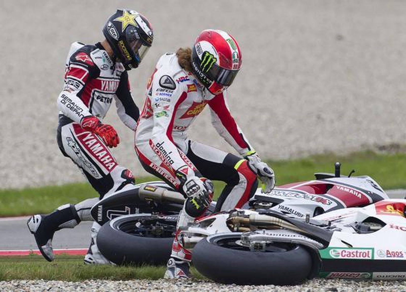 Marco Simoncelli se cayó y se llevó por delante a Jorge Lorenzo.

Foto: Reuters