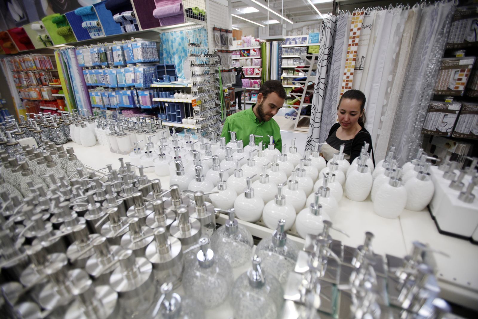 Un vendedor de Leroy Merlin con una clienta en la zona de dispensadores de jabón.