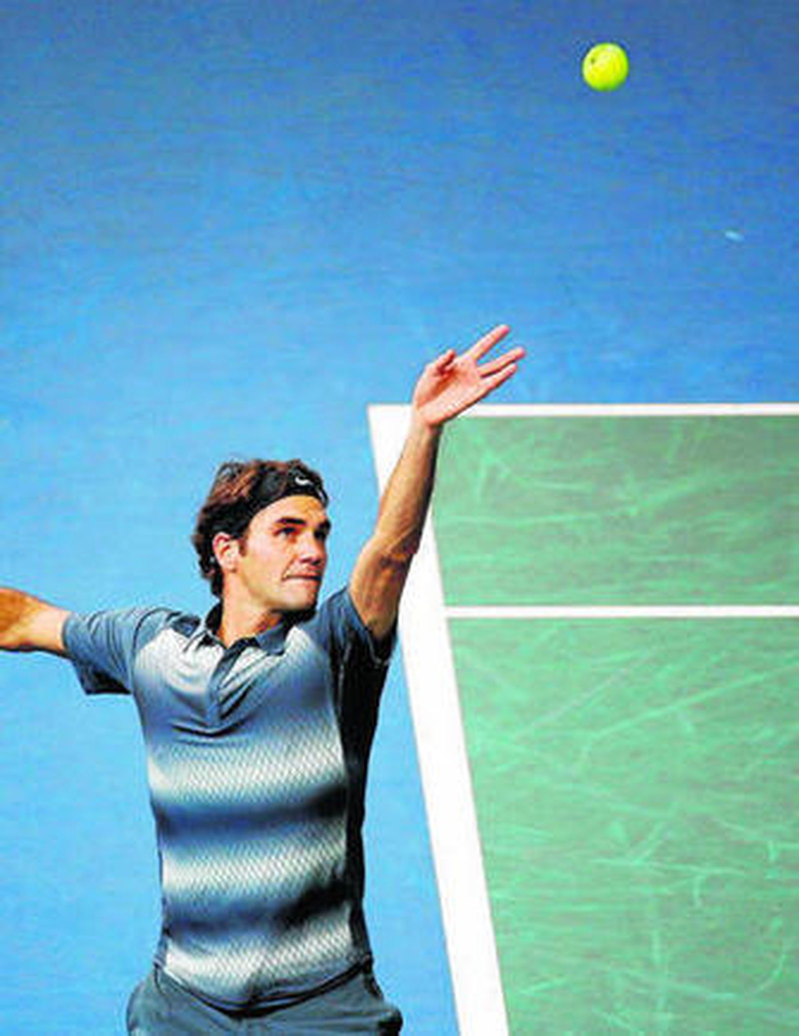 Federer se prepara para efectuar un saque.