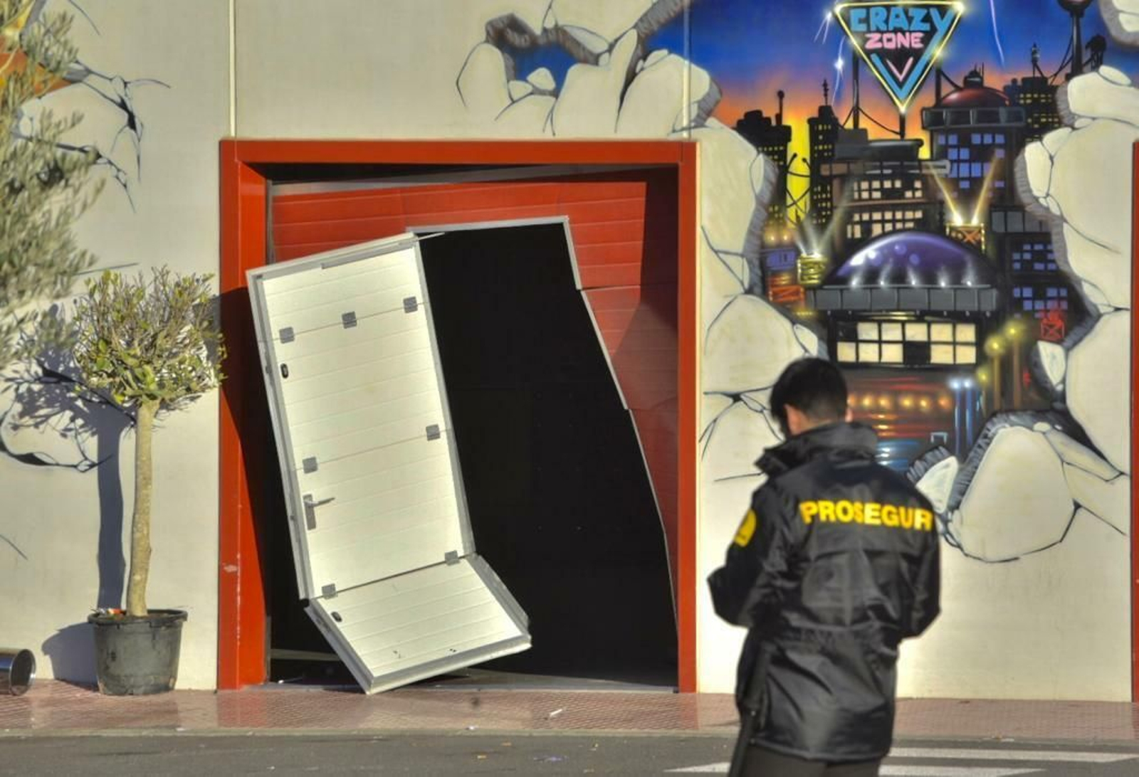 Un vigilante de seguridad, ante la puerta reventada de la nave.