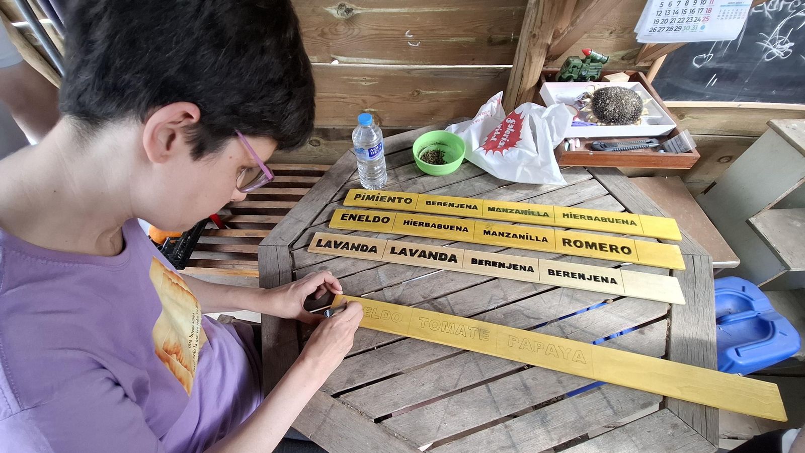 Dentro del taller creativo dan forma a los letreros que nombran las distintos plantas