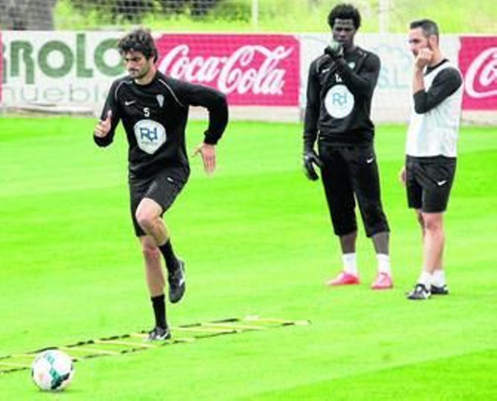 Fran Cruz supera obstáculos sin balón ante la mirada de Razak y Abel Gómez.