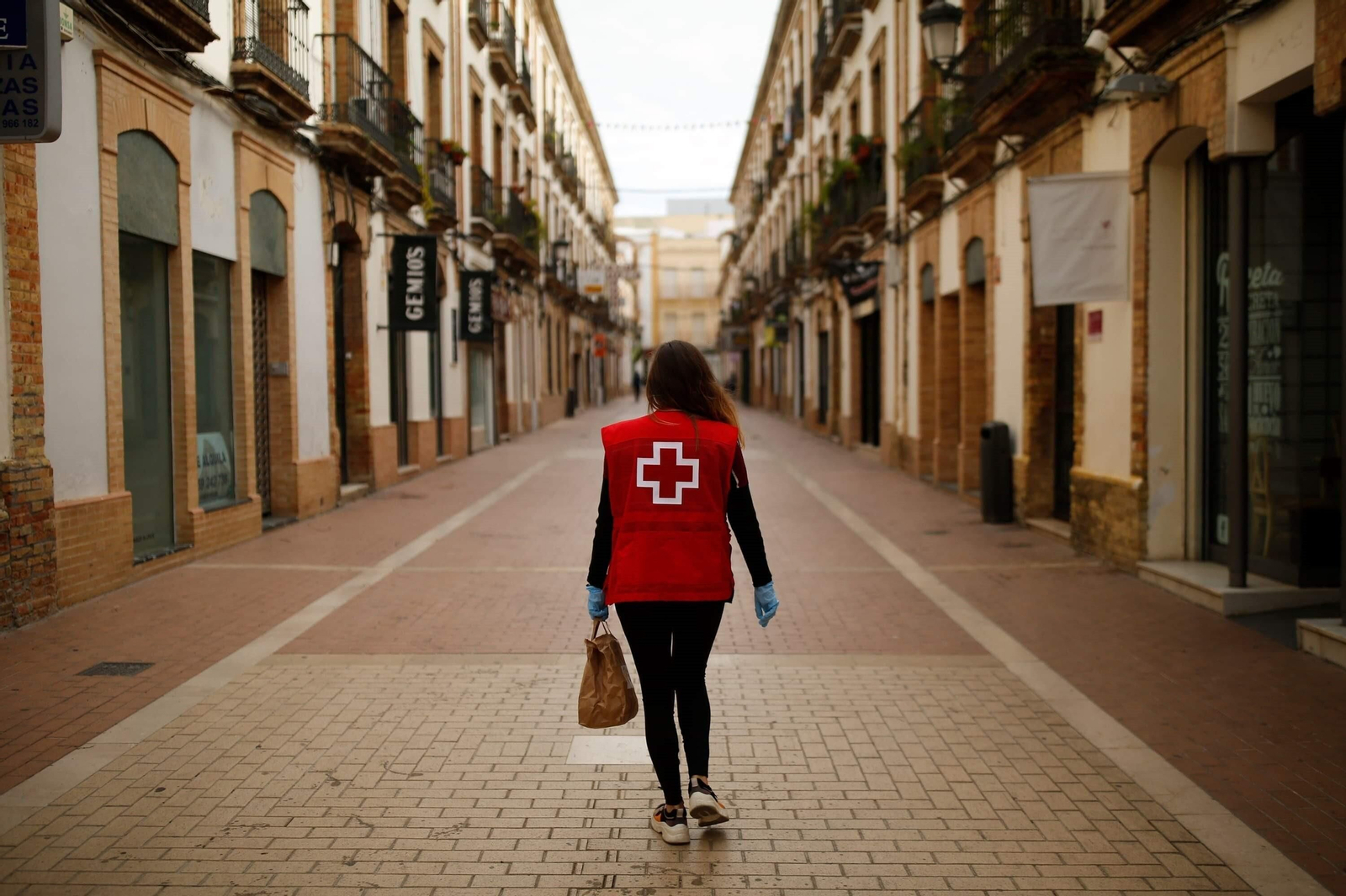 Una voluntaria de Cruz Roja entrega un menú solidario en el confinamiento.