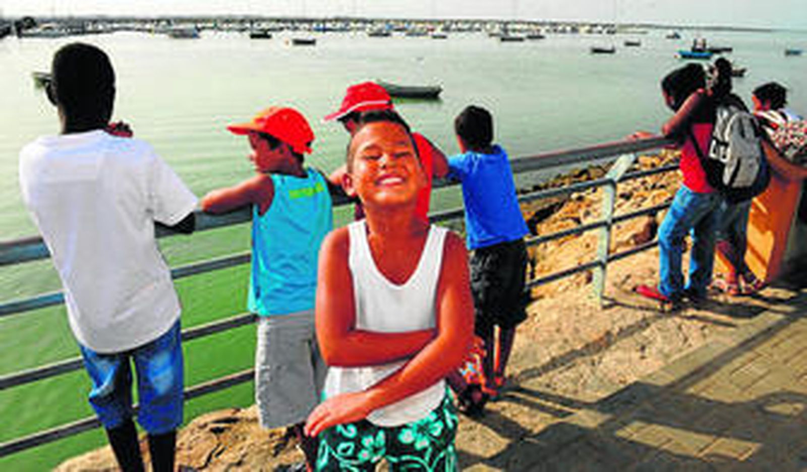 Los jóvenes saharauis esperan en el muelle de Gallineras la llegada del barco que los trasladó hasta Sancti Petri.